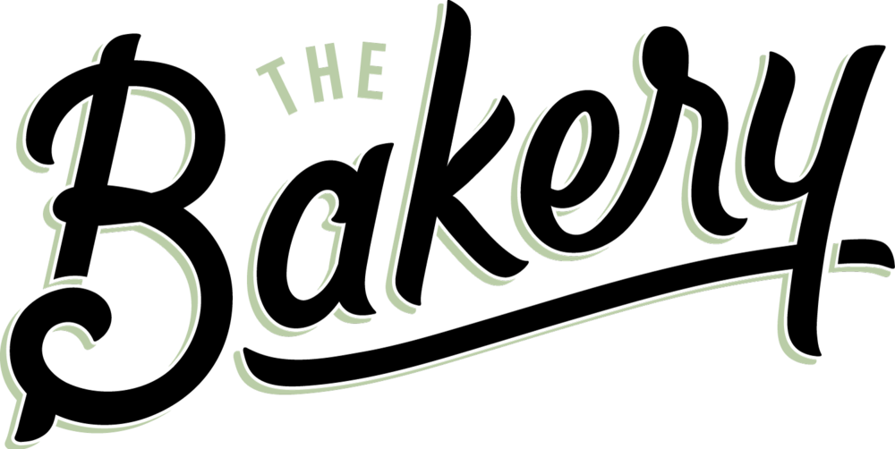 麵包店標誌設計 壁紙 — 黑色背景上帶有裝飾性花飾的「The Bakery」優雅淺綠色草書標誌。