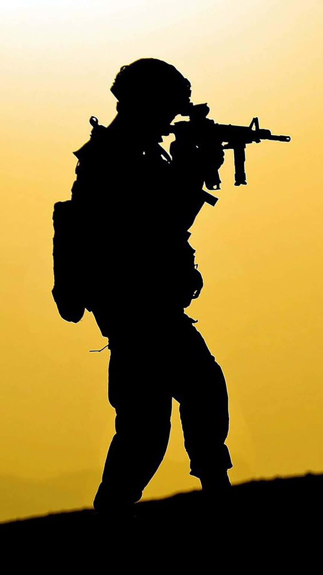 士兵剪影在日落時手持步槍。
