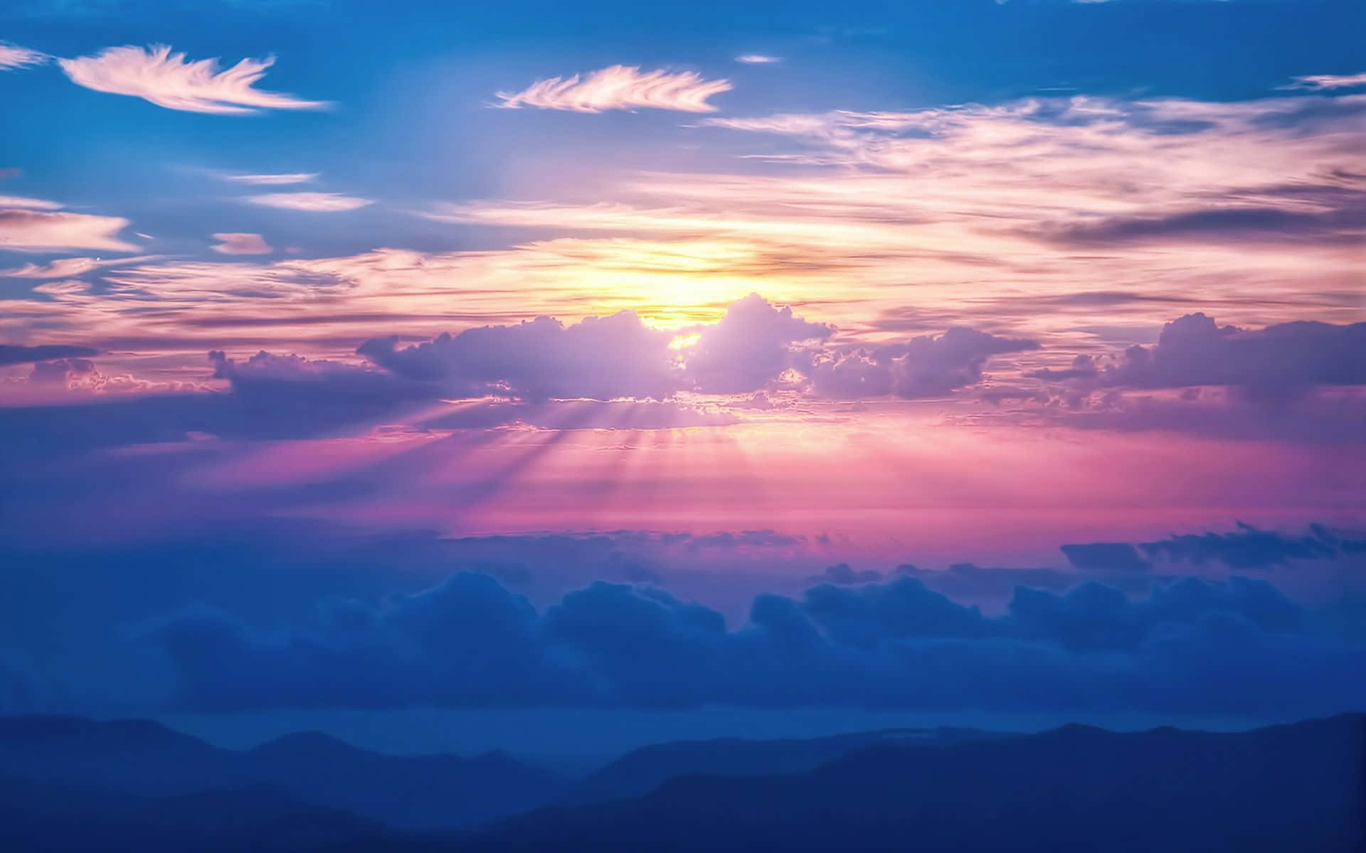 夕陽穿過多彩雲層，照耀在山脈之上。