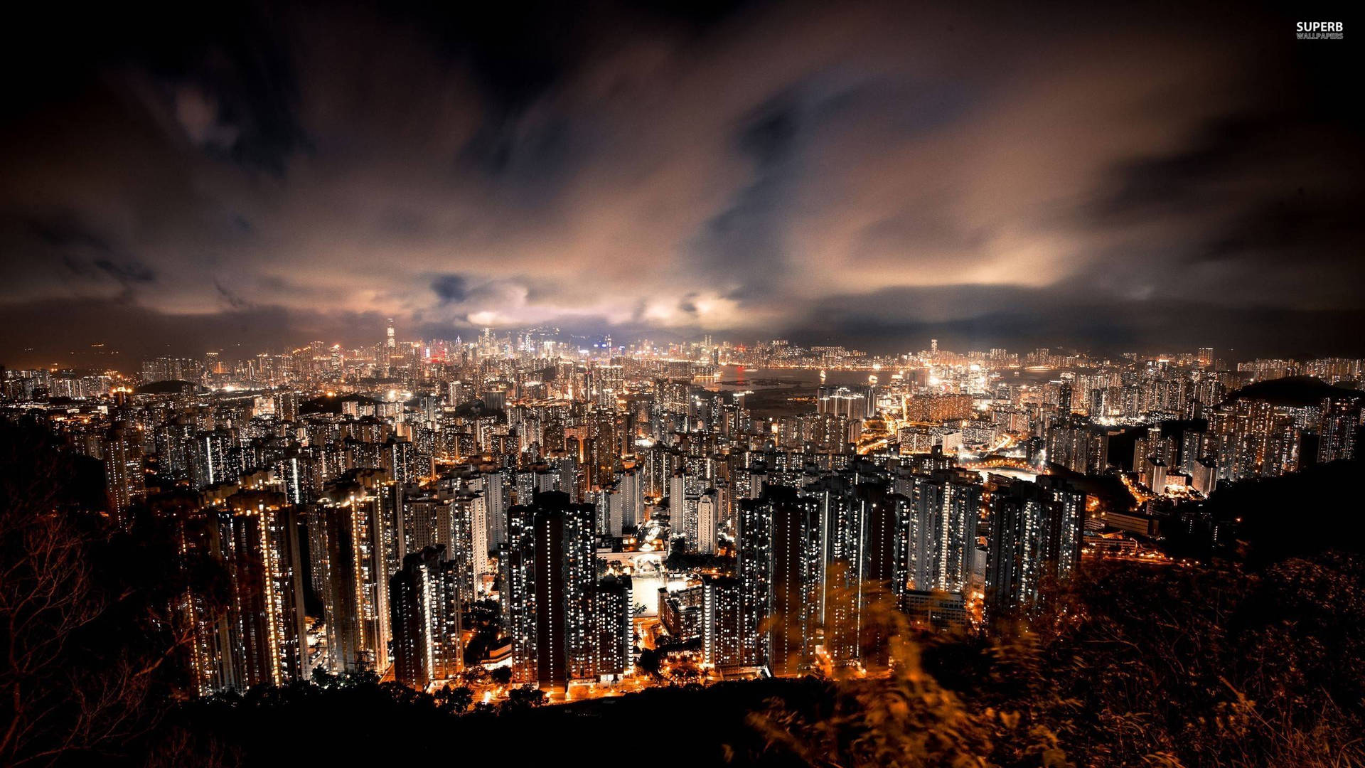 夜晚密集的城市，發光的建築和頭頂上的烏雲。