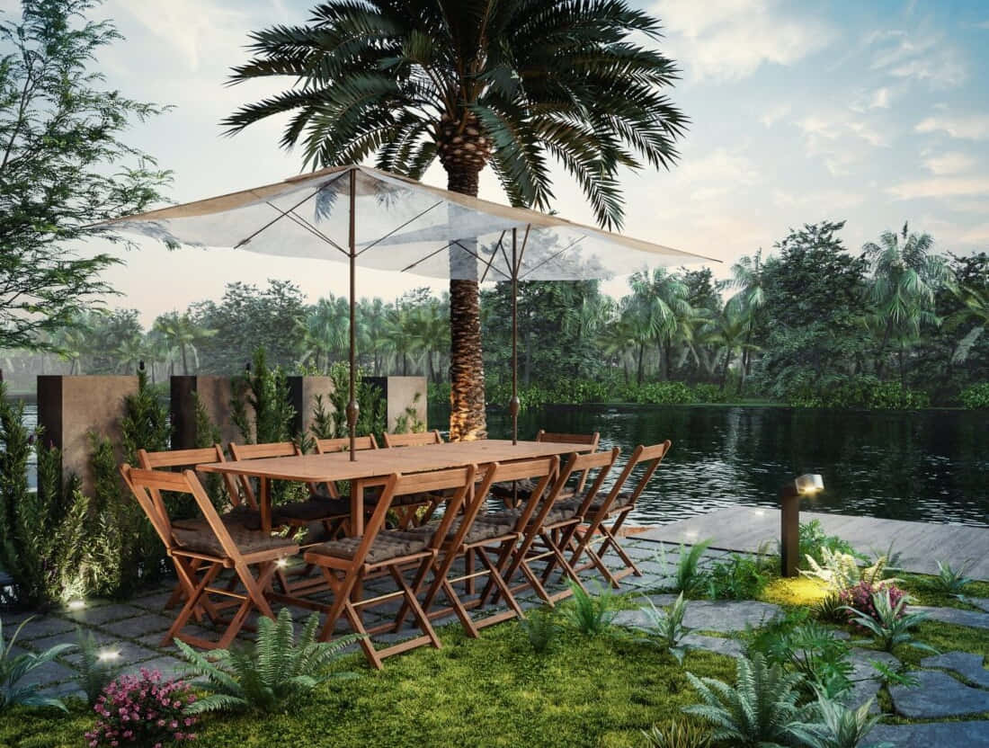 3d Landscape 桌布 壁紙 — 黃昏時分，一個大型遮陽傘下的木製餐桌套裝，旁邊是一個寧靜的池塘，周圍環繞著茂密的熱帶植物和棕櫚樹。