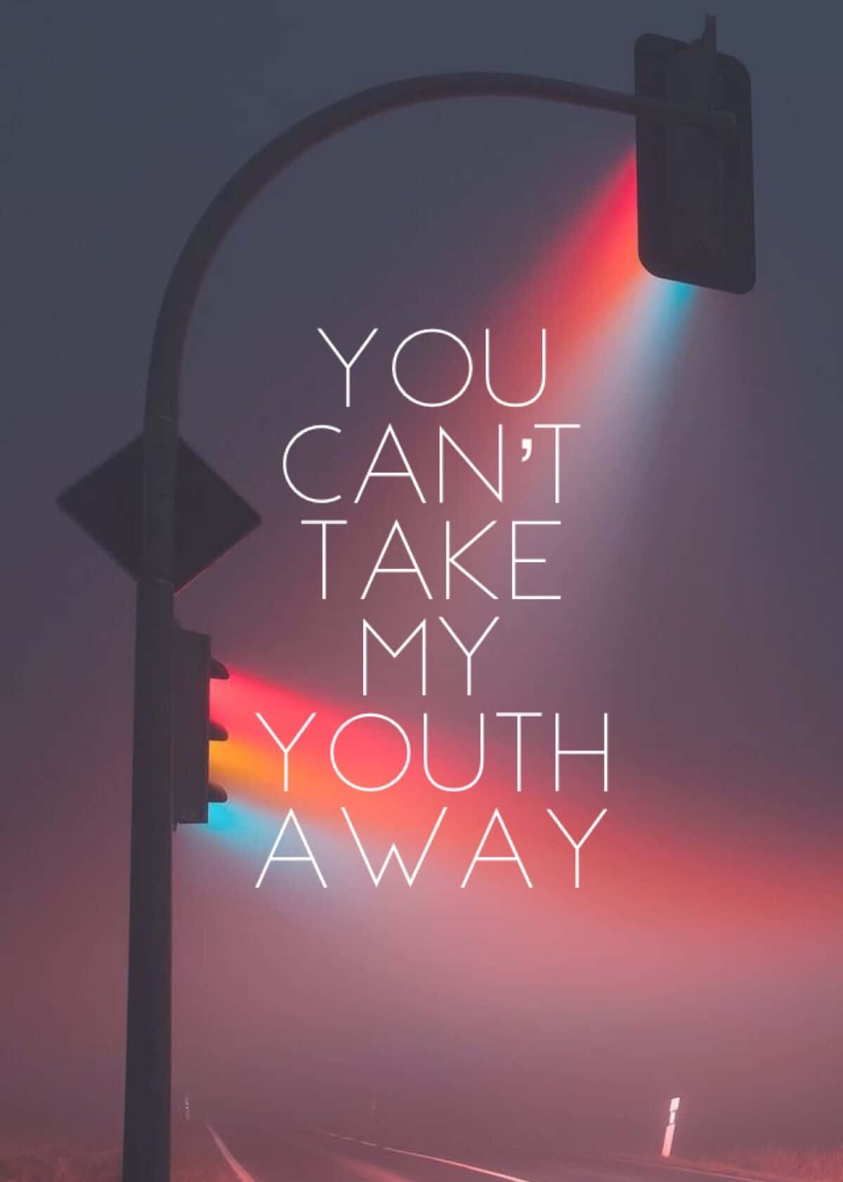 Youthful 桌布 壁紙 — 黃昏時分，一條霧街，交通燈在粗體白色文字「YOU CAN'T TAKE MY YOUTH AWAY」後面投射出紅色和藍色的光束。