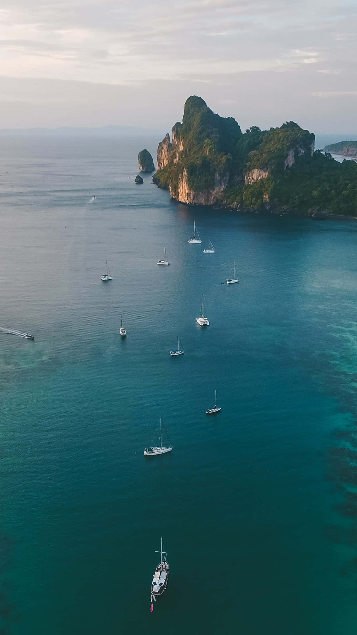 Boating 桌布 壁紙 — 黃昏時分，翠綠的喀斯特島嶼附近，點綴著帆船的碧綠海水鳥瞰圖。
