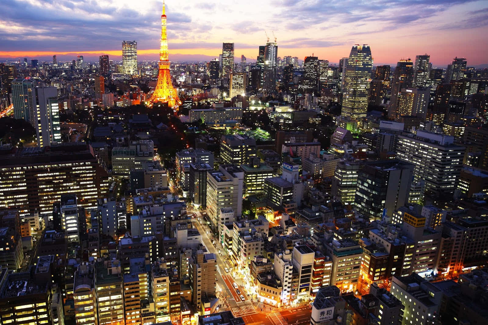 東京 桌布 壁紙 — 黃昏時分東京的鳥瞰圖，東京塔在紫橙色天空中閃耀。