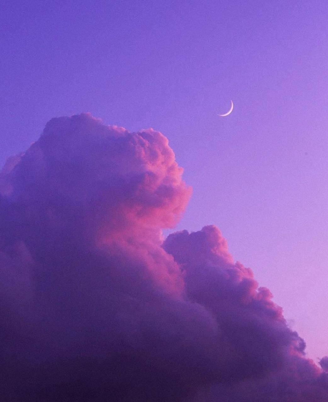 暮色中紫色粉紅雲層上的新月