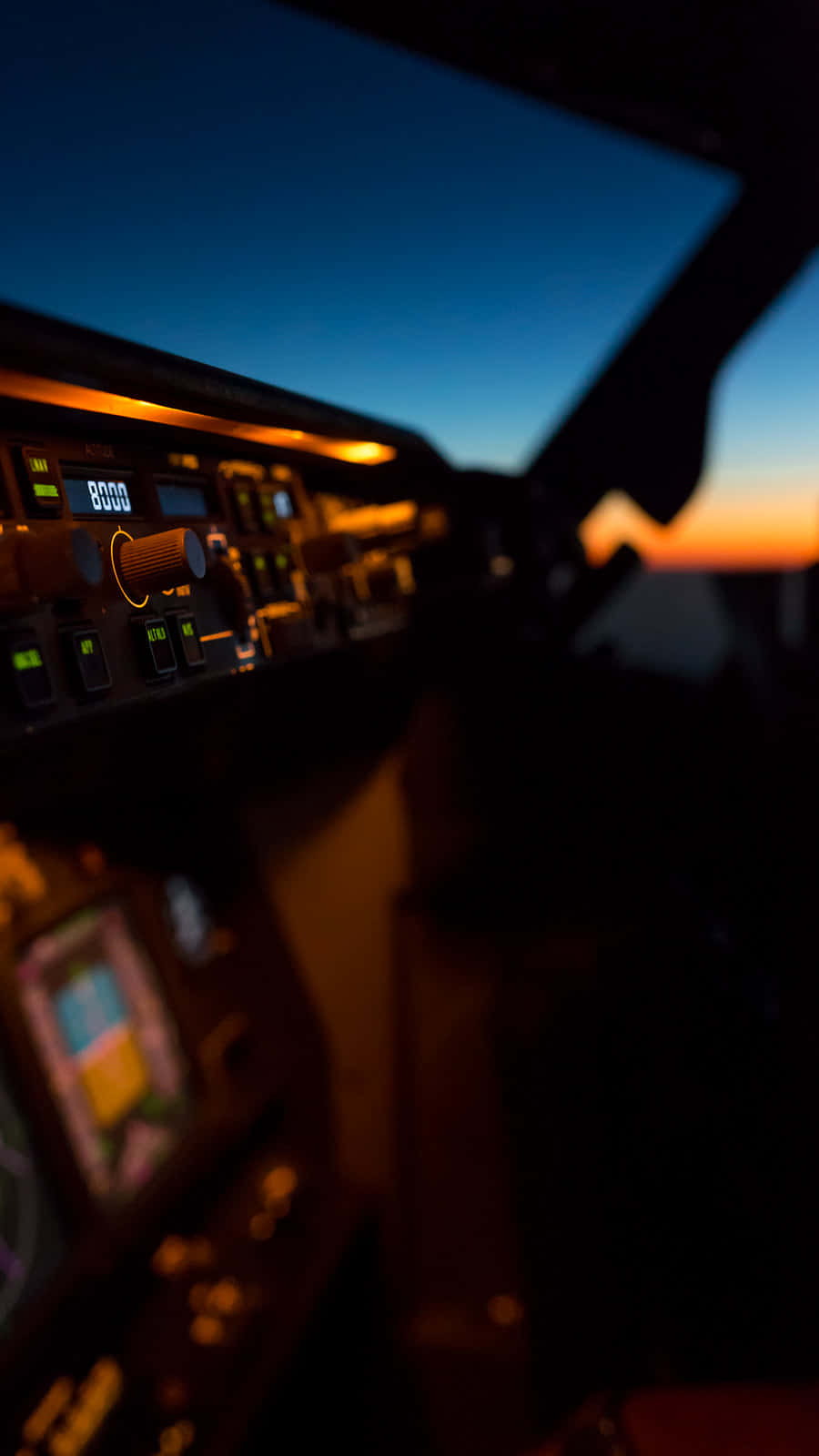 Aviation 桌布 壁紙 — 黃昏時分的飛機駕駛艙，發光的儀表板和外面藍橙漸變的天空。
