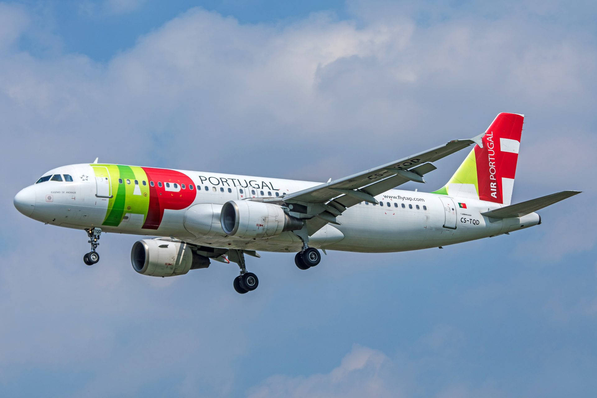 葡萄牙航空飛機以彩色塗裝在藍天白雲中降落