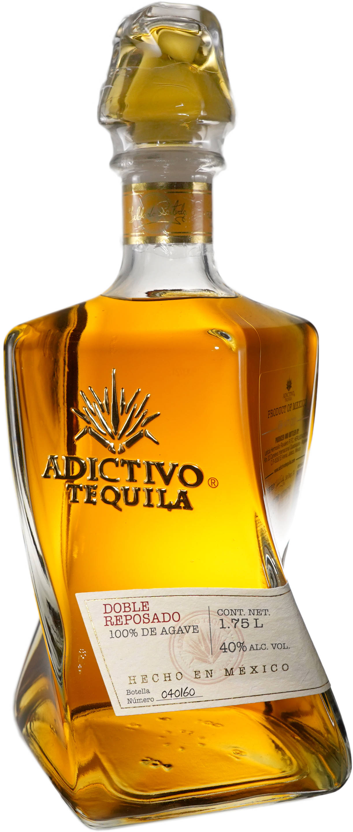 黃色Adictivo陳釀龍舌蘭酒 壁紙 — 一瓶透明玻璃瓶的Adictivo Tequila Doble Reposado，帶有金色琥珀色液體和金色箔紙頸封。