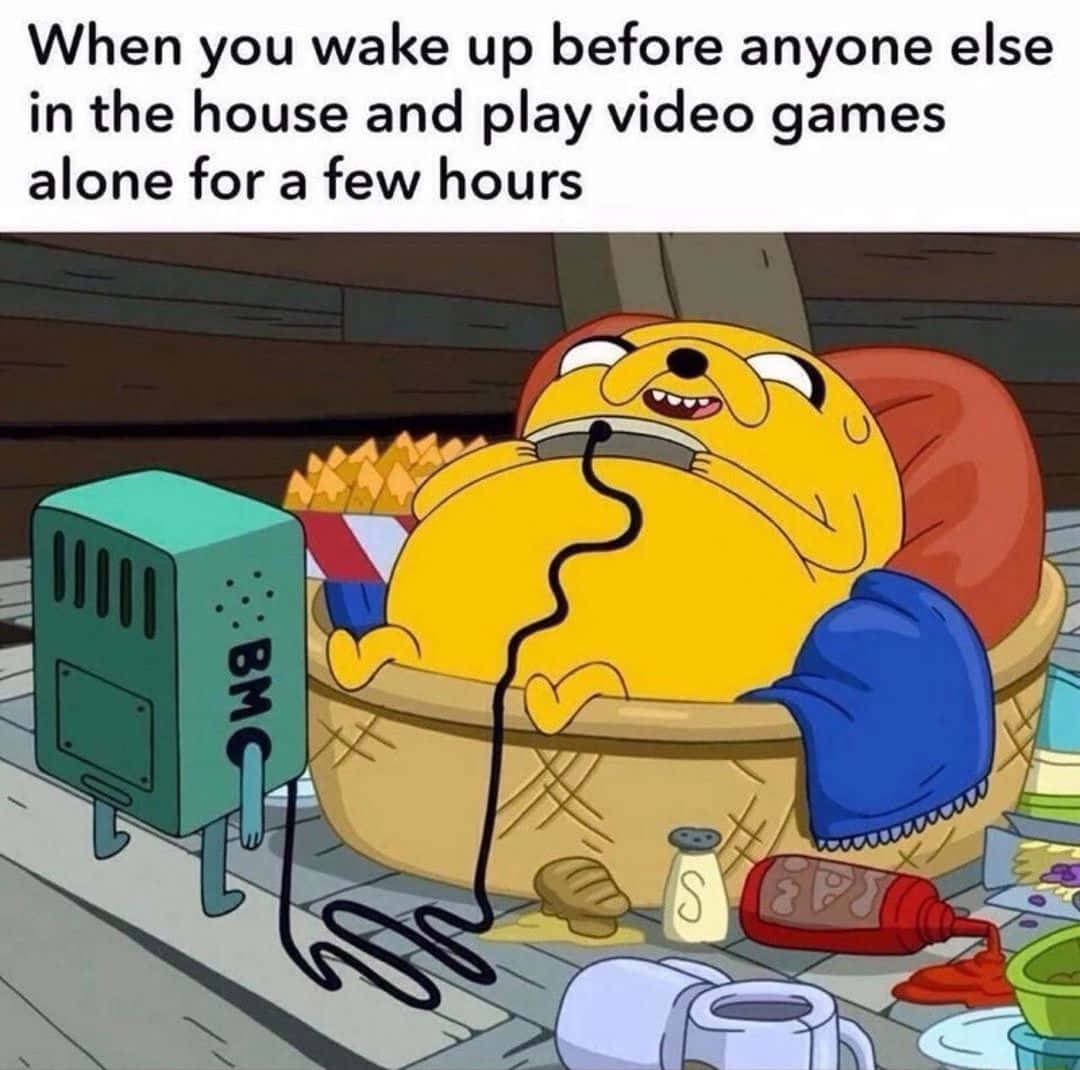 Gaming Memes 桌布 壁紙 — 黃色卡通狗喺亂糟糟嘅籃仔度攤唞，食緊薯條同時打緊機，周圍係亂糟糟嘅廚房。