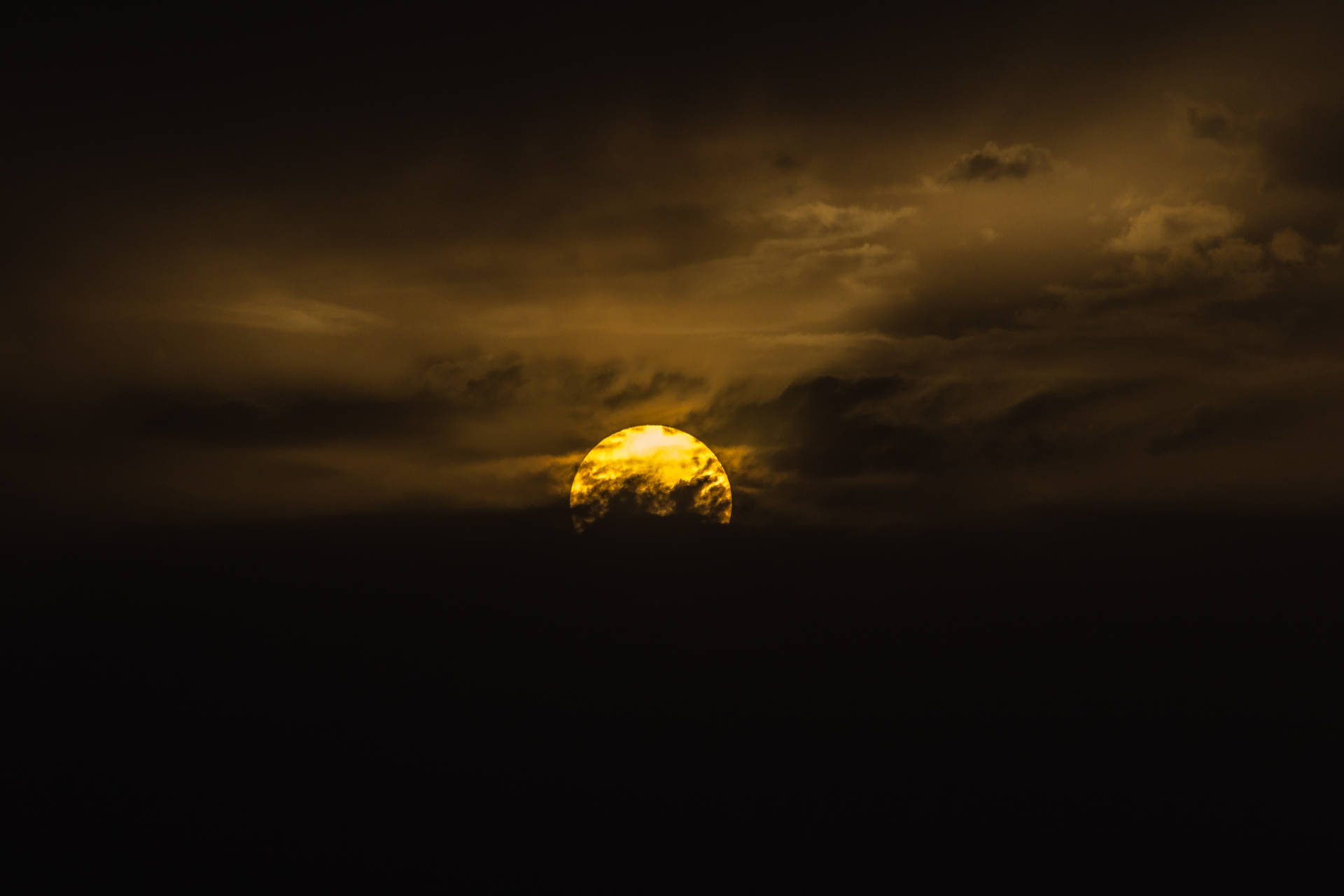 金色太陽在日落時分穿透黑暗的暴風雲。