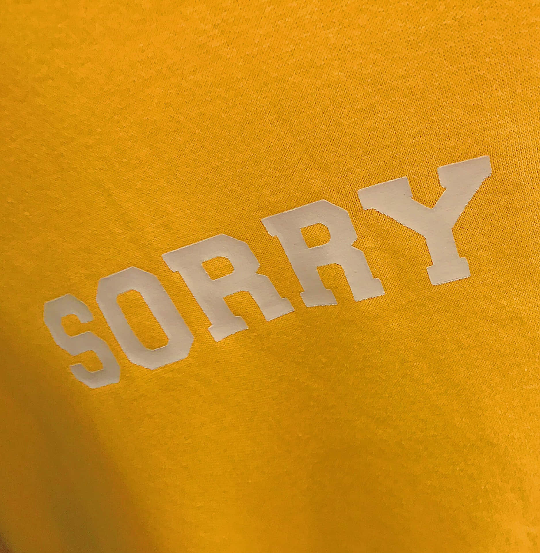 金黃色T恤，白色粗體「SORRY」文字。