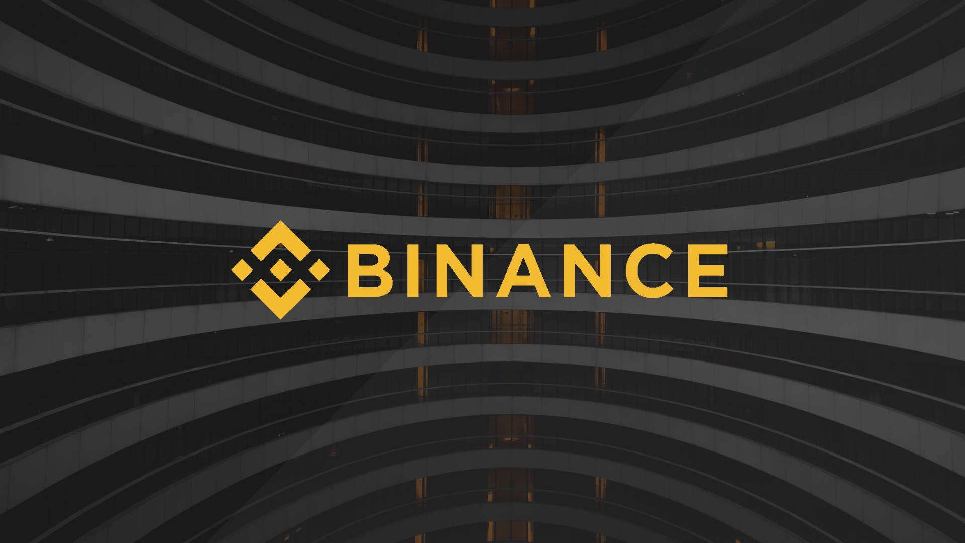 黃色幣安曲線 壁紙 — 大膽的黃色 Binance 標誌居中於一座帶有弧形玻璃陽台的深色現代建築前。
