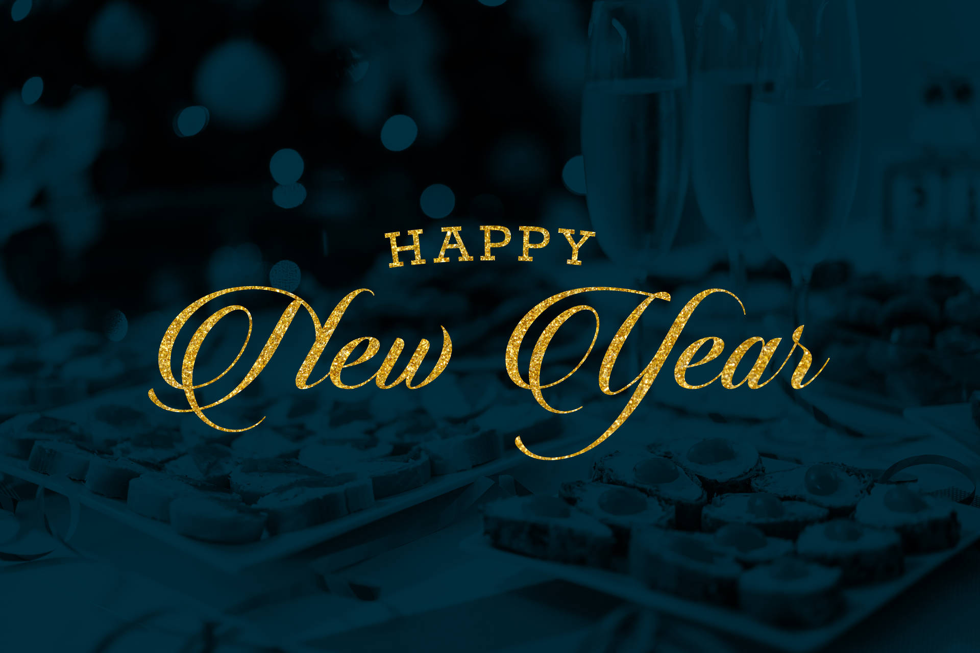 金色「Happy New Year」文字在模糊的香檳和朱古力上方。