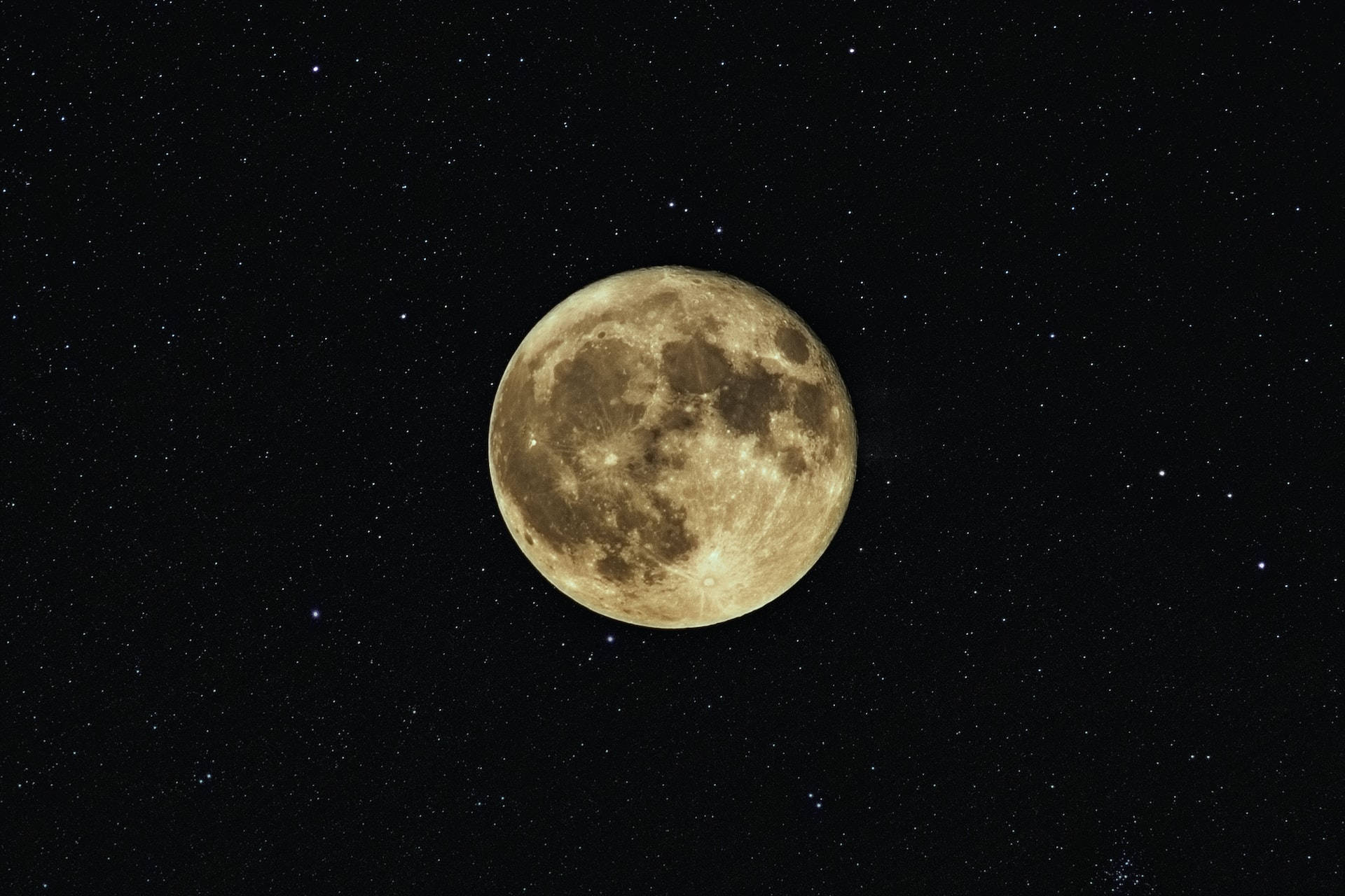 滿月在繁星點點的夜空中發光，可見隕石坑和月海。
