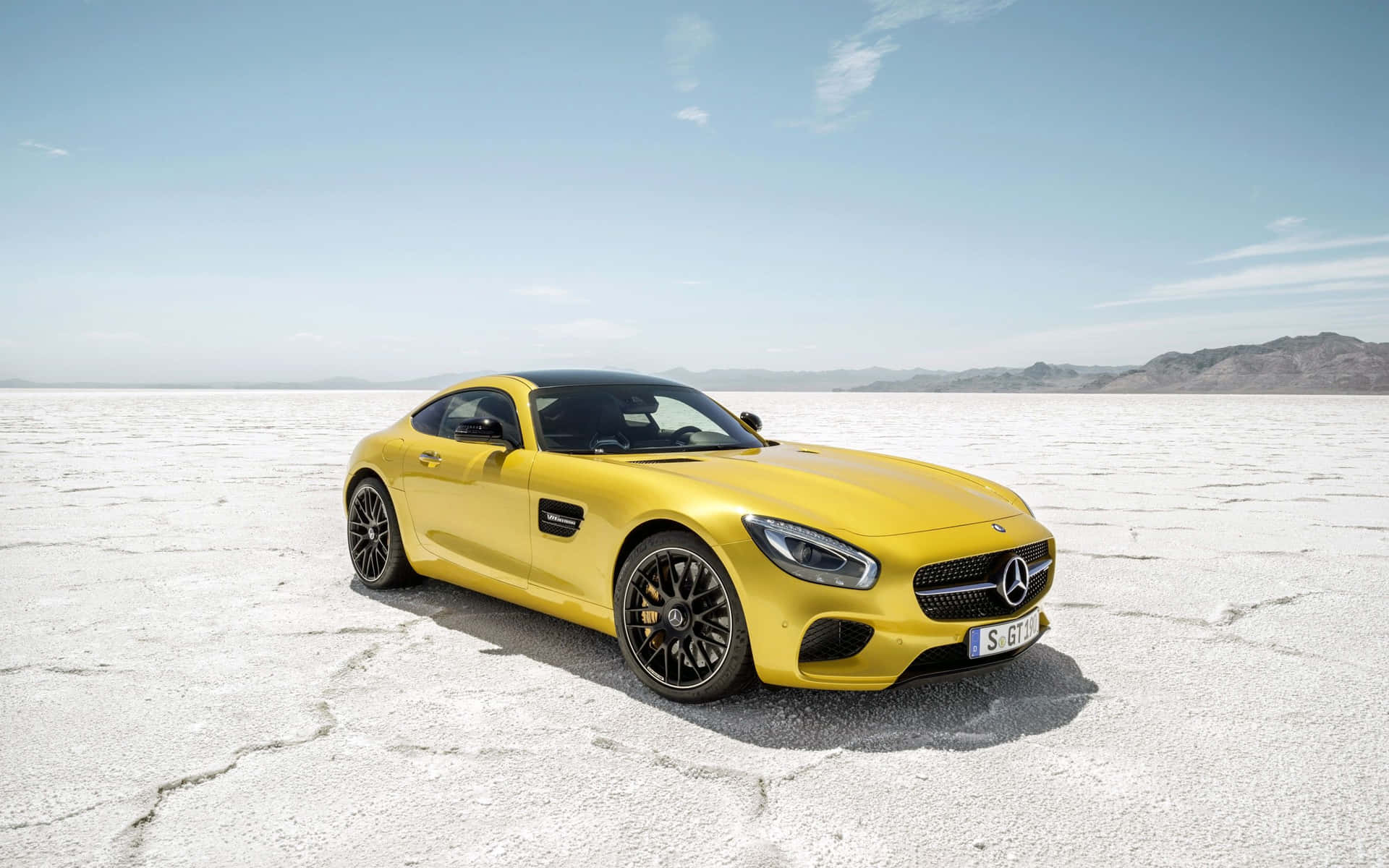 藍天下，廣闊鹽灘上的黃色 Mercedes-AMG GT S 與遠山。