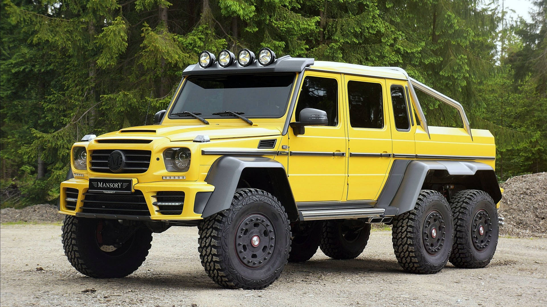 黃色Mansory G-Class SUV停泊在碎石上，靠近森林