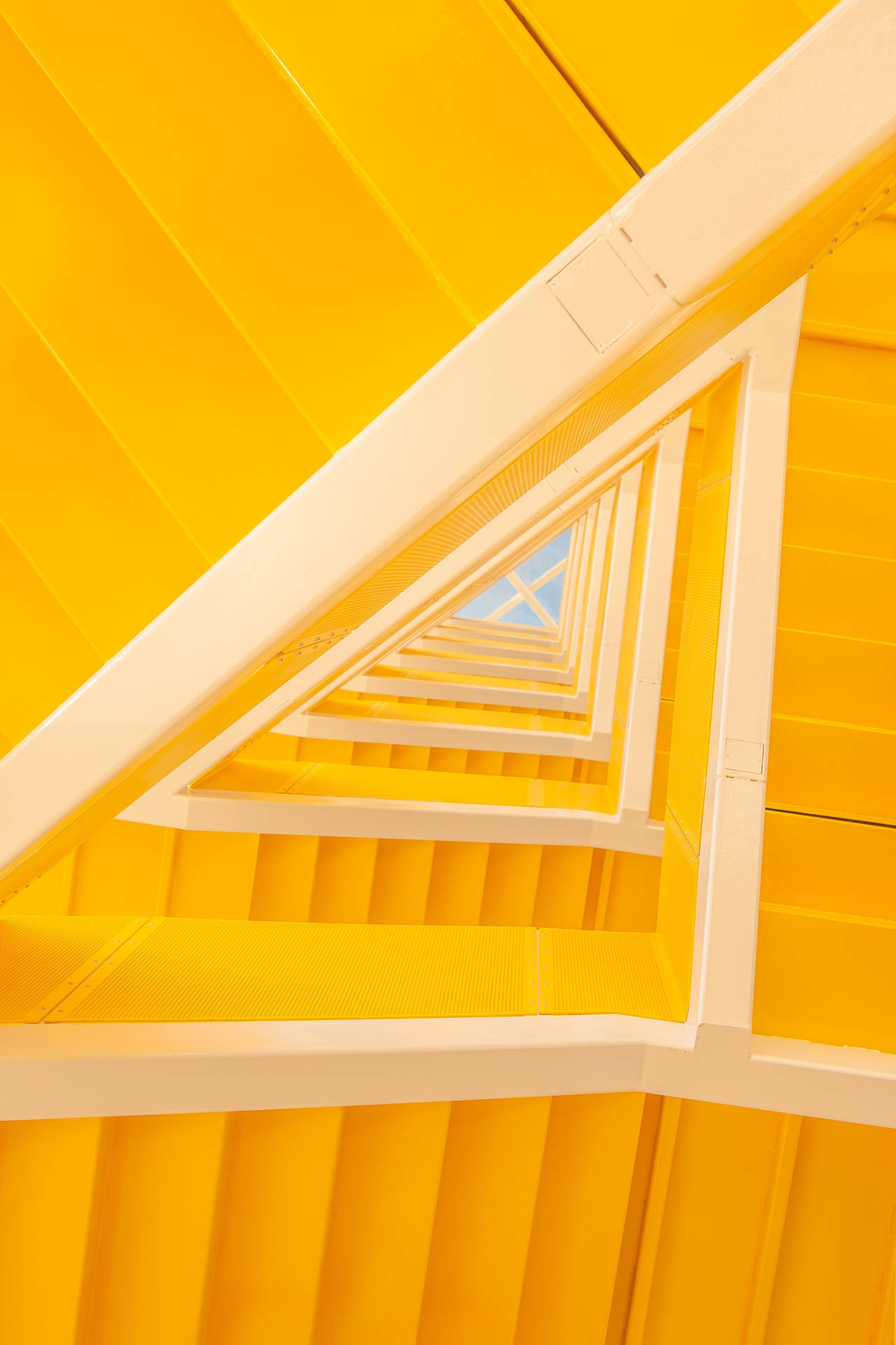 黃色樓梯螺旋向上通往藍天。