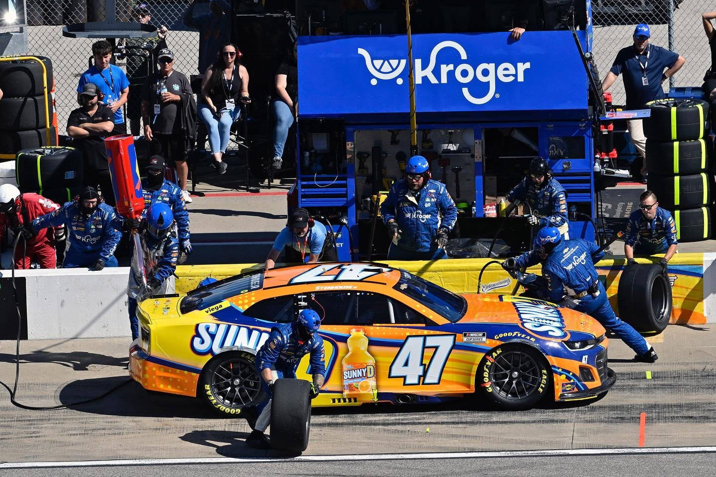 NASCAR維修站人員在日間比賽中為Sunny D贊助的賽車更換輪胎。