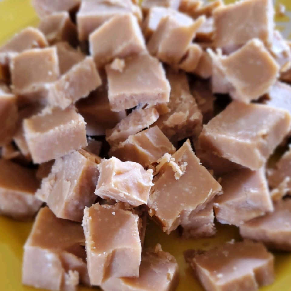 Penuche Fudge 桌布 壁紙 — 黃色碟上嘅立方體軟糖塊近鏡，質地平滑。