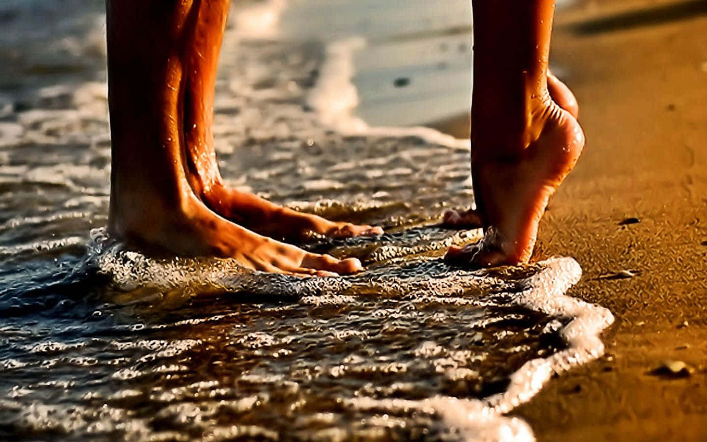 Beach Love 桌布 壁紙 — 黃金日落時分，赤腳踏進沙灘溫暖海浪的特寫。