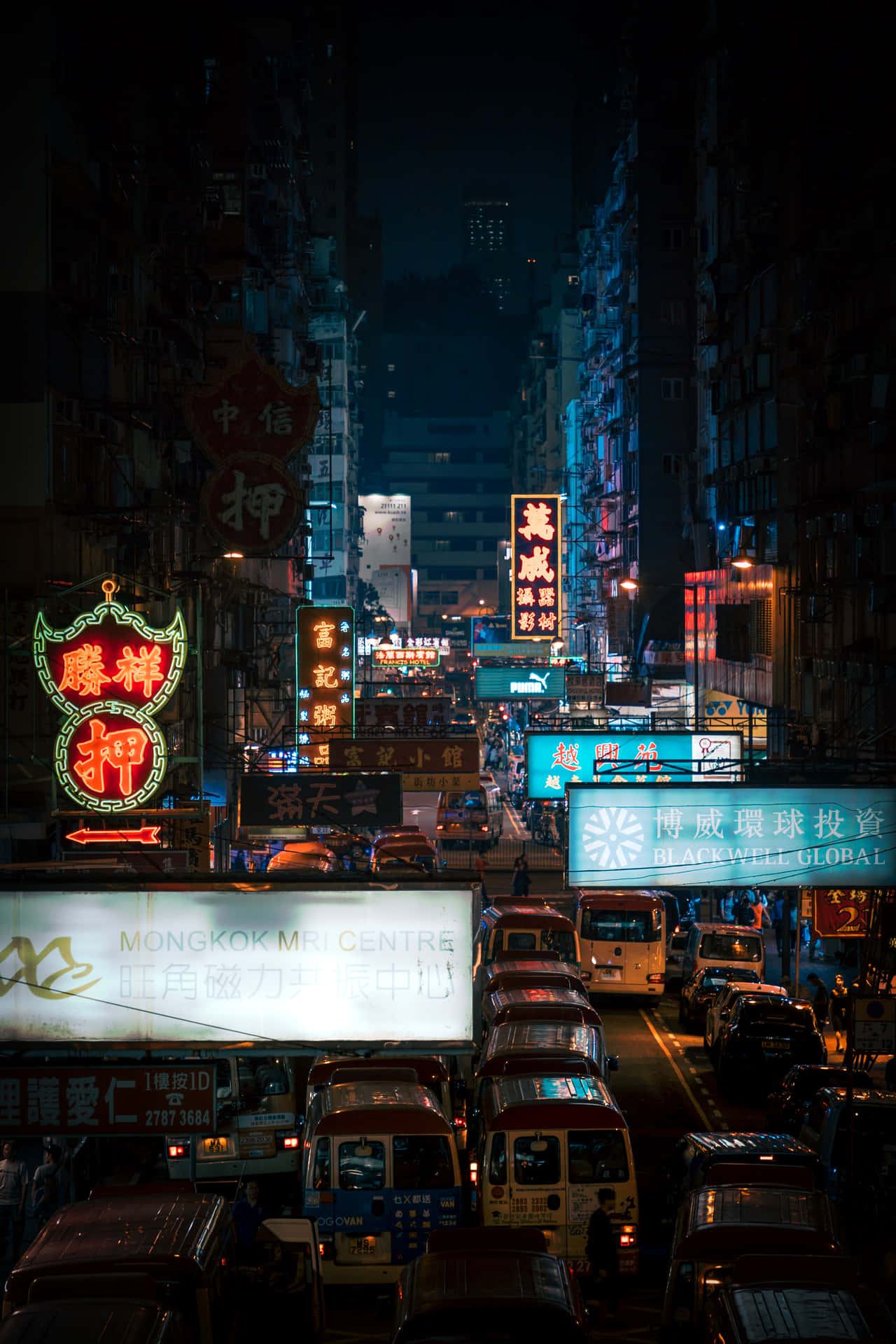 黃金時刻的維多利亞港天際線 壁紙 — 夜晚一條繁華嘅霓虹燈城市街道，高樓大廈、發光招牌同車水馬龍嘅道路。