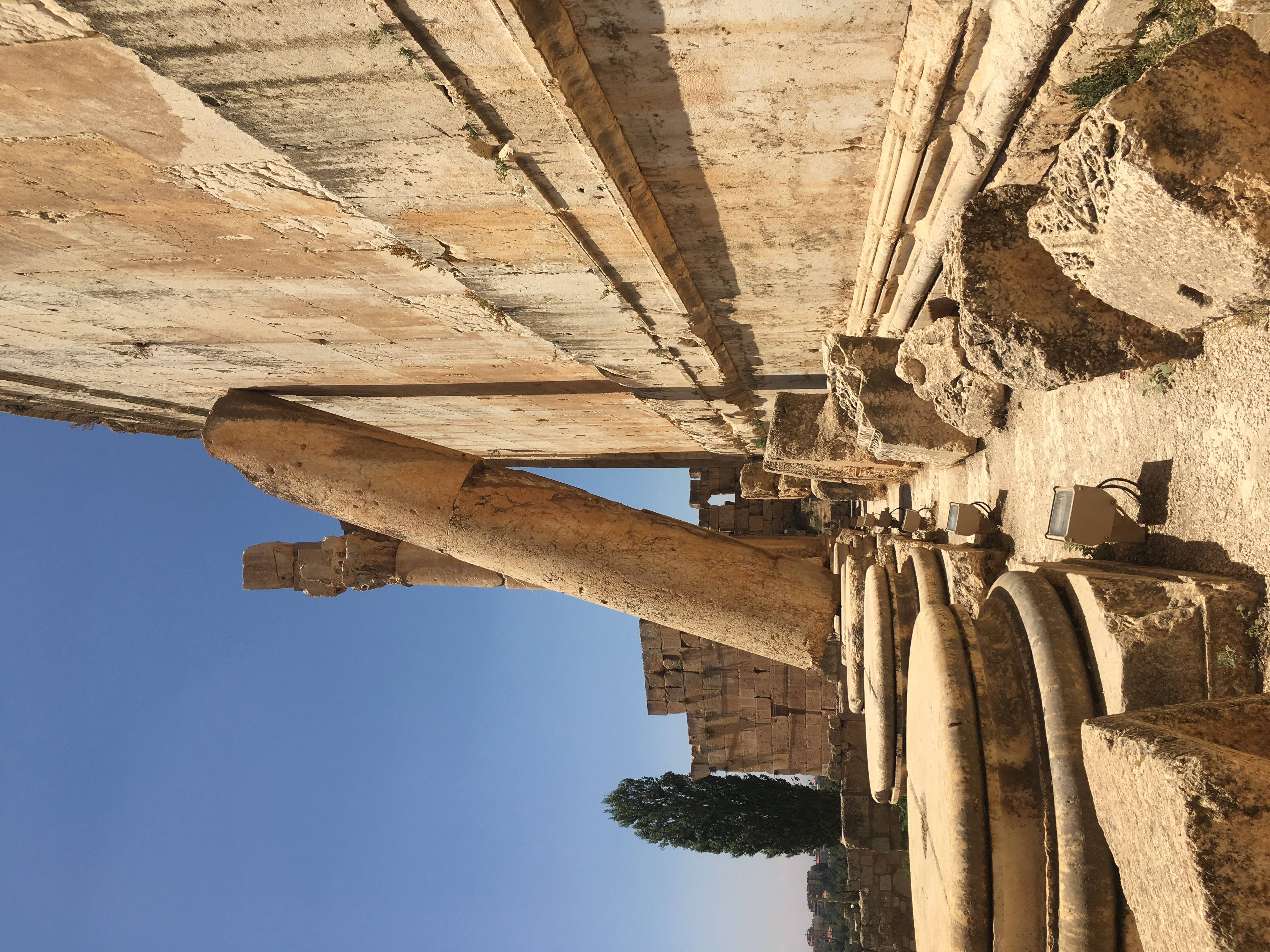 黎巴嫩石砌建築 壁紙 — 歷史遺跡的古老石柱和 crumbling 牆壁在晴朗的藍天下高聳矗立。