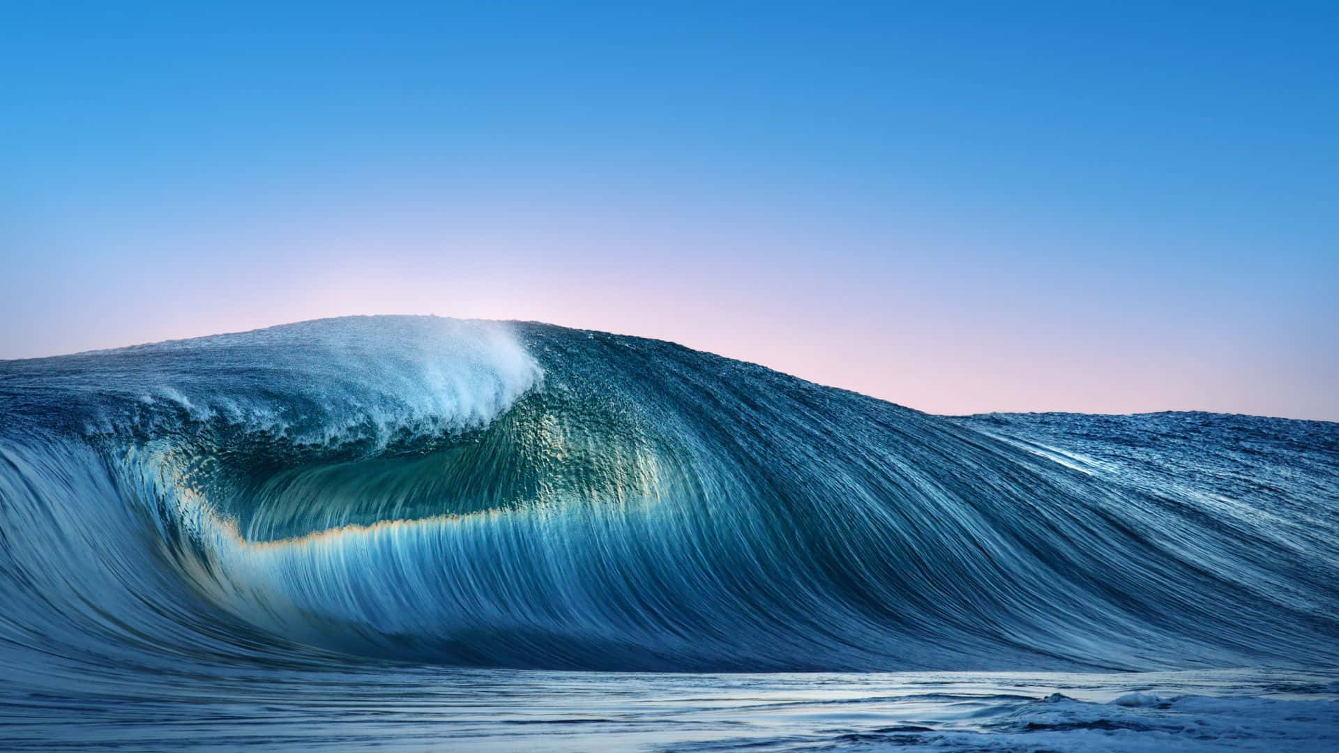 waves 桌布 壁紙 — 黎明時分，巨大的海浪在從藍色漸變到柔和粉紅色的天空下完美捲曲。