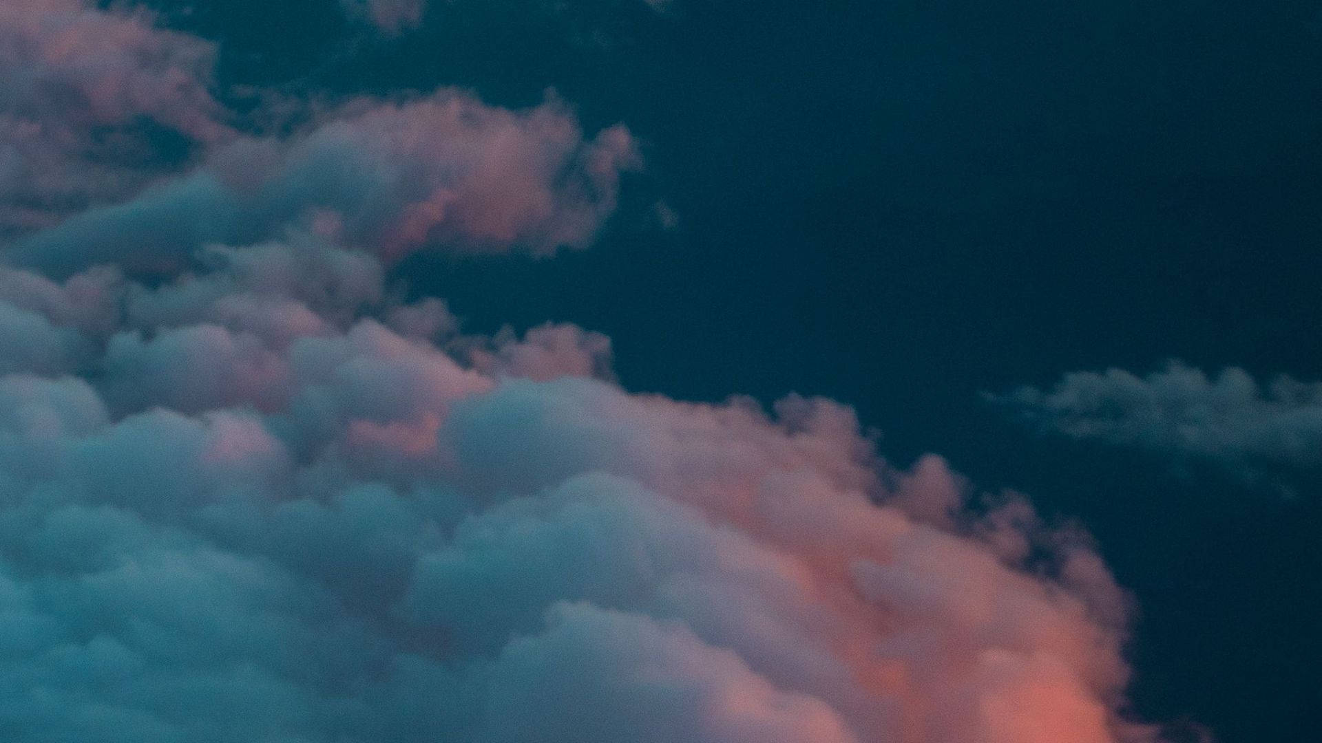 黎明時分天空景觀 壁紙 — 柔軟的雲朵在深沉的暮色天空中散發出粉紅色和藍綠色的光芒。