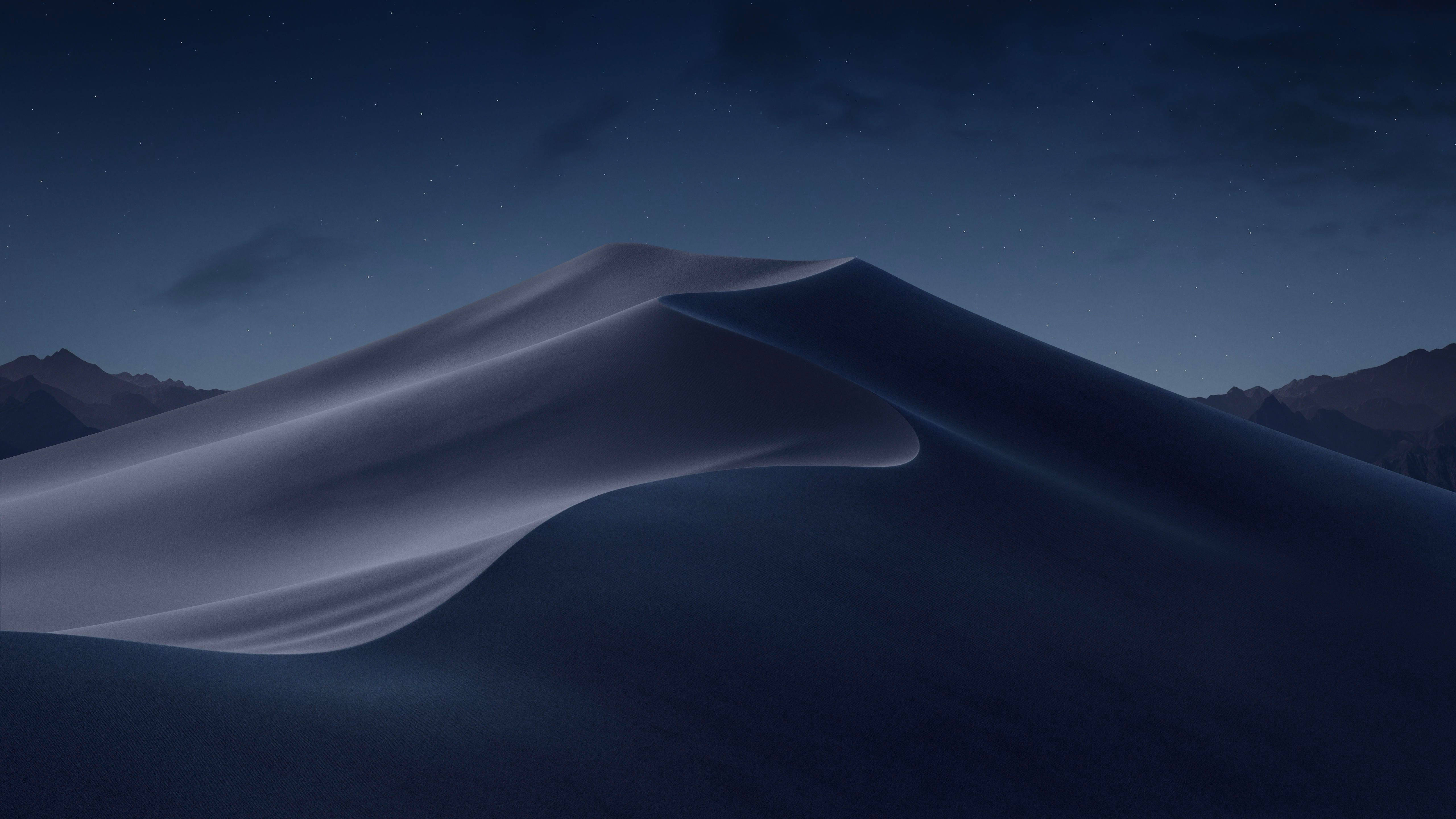 黎明沙漠MacOS 壁紙 — 寧靜的夜晚場景，在星空下展現平滑起伏的沙丘，遠方山巒作為背景。