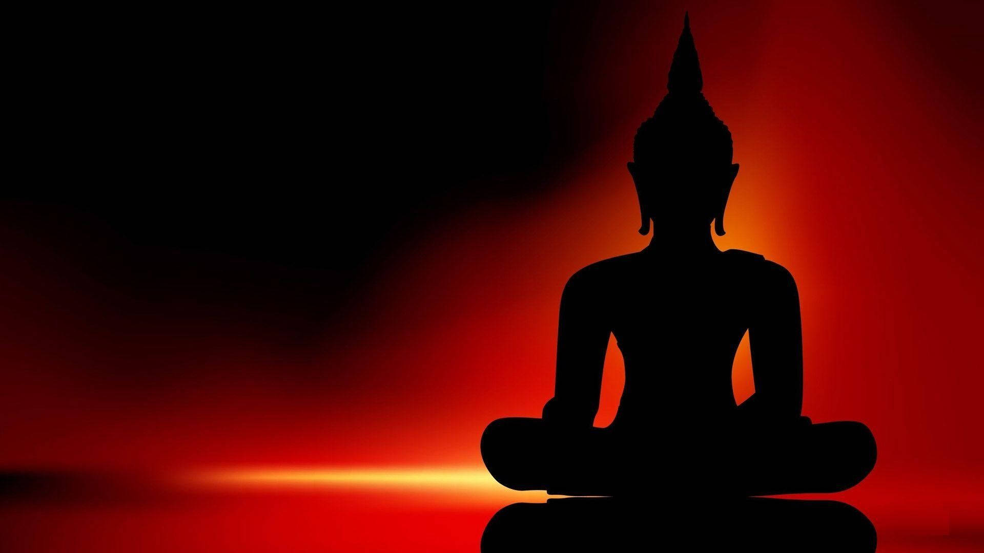 佛像剪影在熾熱的紅色夕陽背景下冥想。