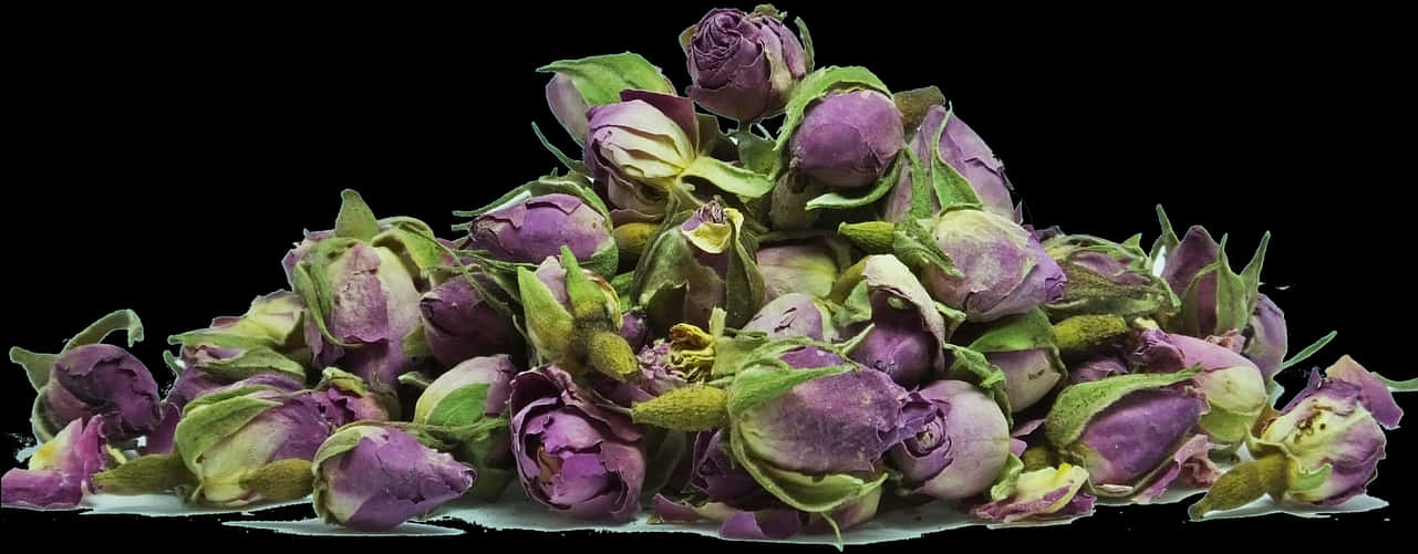 黑底乾燥玫瑰花蕾 壁紙 — 一堆乾燥的紫色玫瑰花蕾和綠色花萼放在白色表面上，背景為黑色。