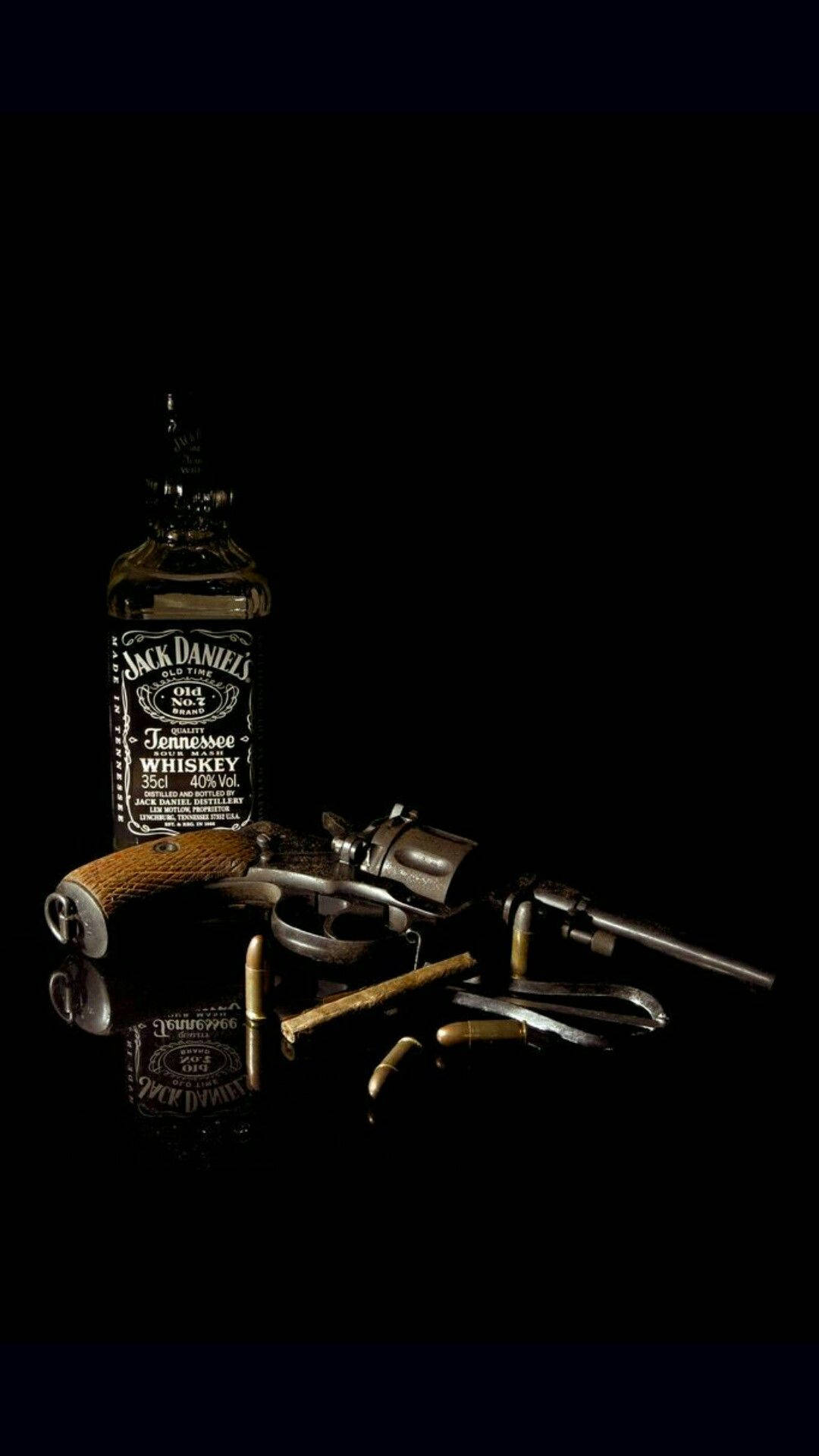 一瓶Jack Daniel's威士忌和一支帶子彈的左輪手槍在深色反射表面上。