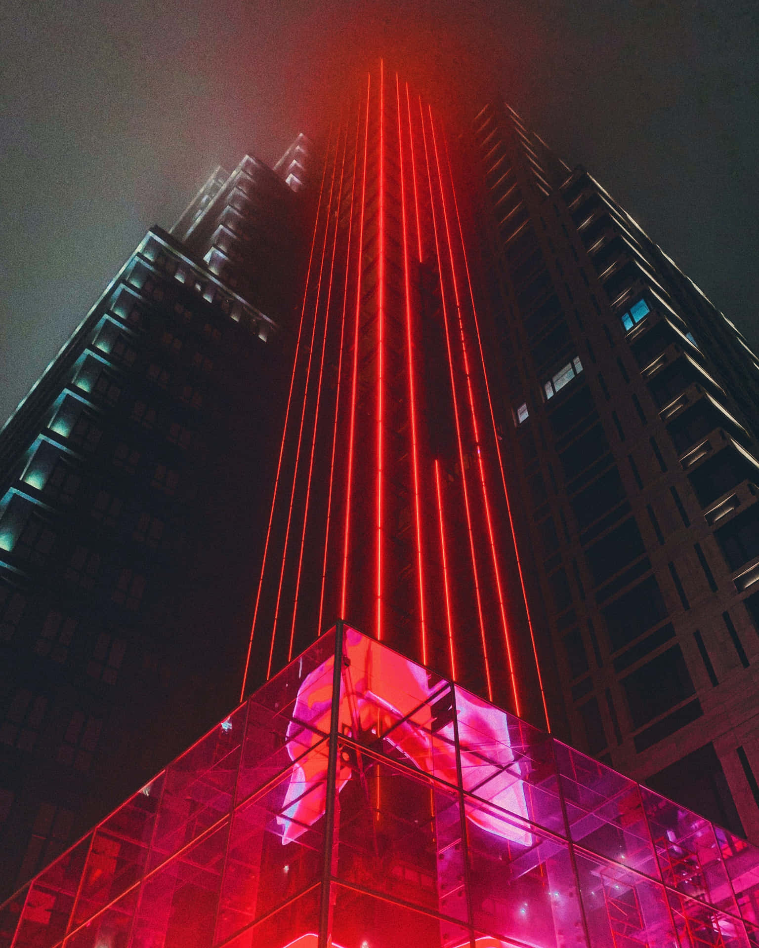 夜晚被紅色激光束和粉紅色玻璃照亮的宏偉建築。
