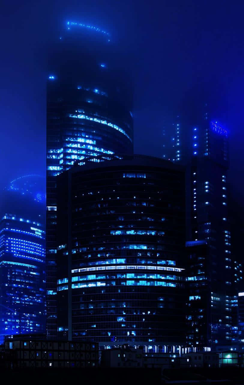 現代摩天大樓在黑暗的夜空中呈現藍色照明。