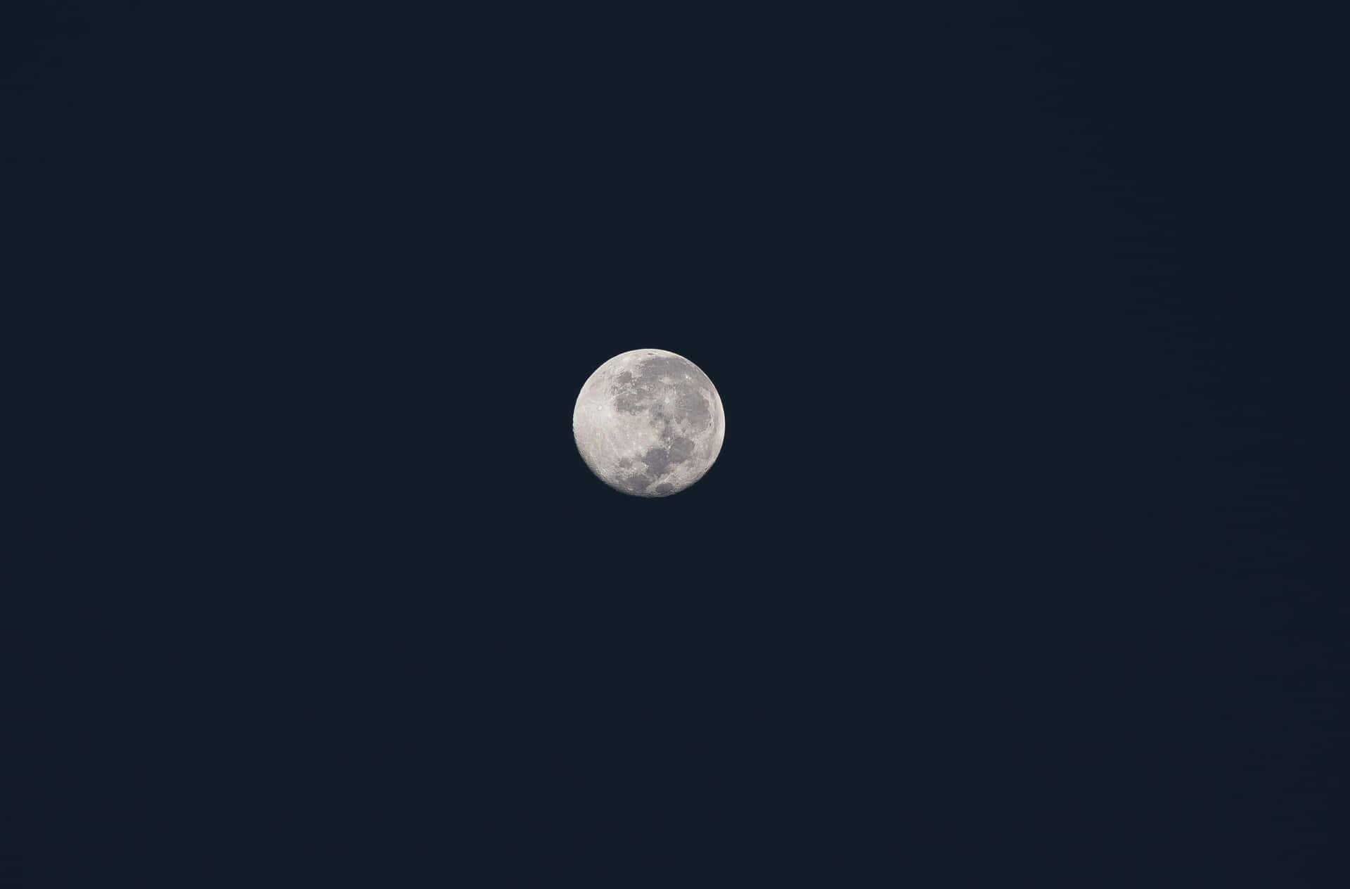滿月位於沒有雲或星星的黑暗夜空中央。