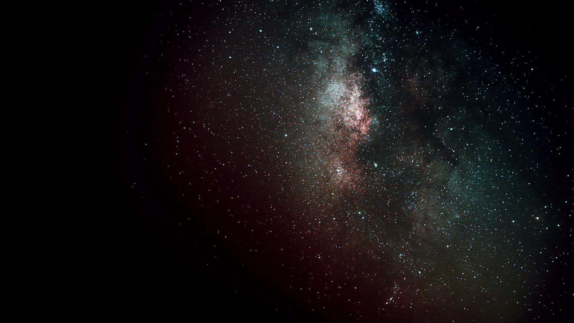 深空中閃耀著粉紅色和藍綠色星雲的銀河系。