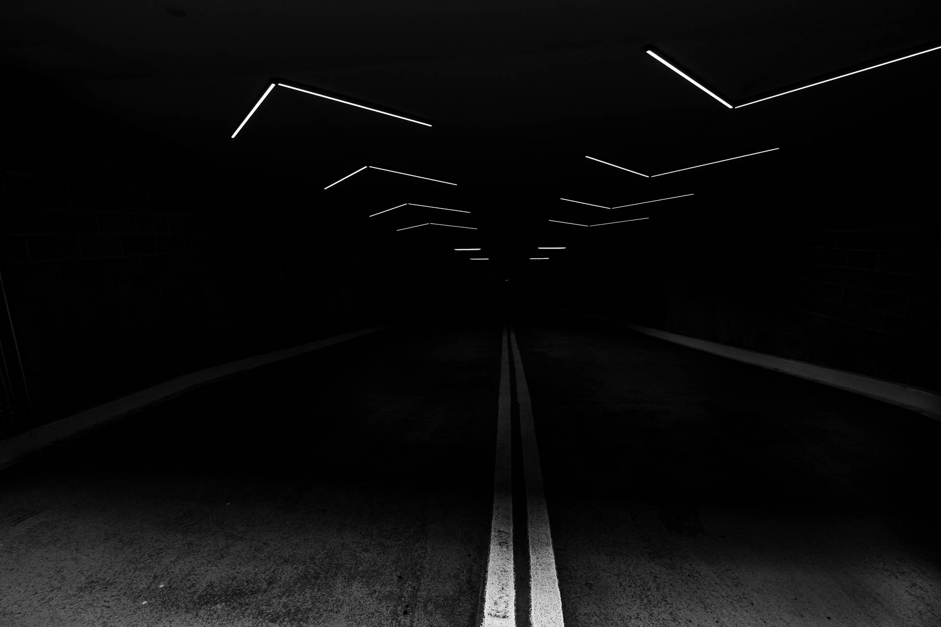 黑暗隧道，發光白色燈光及馬路中心線
