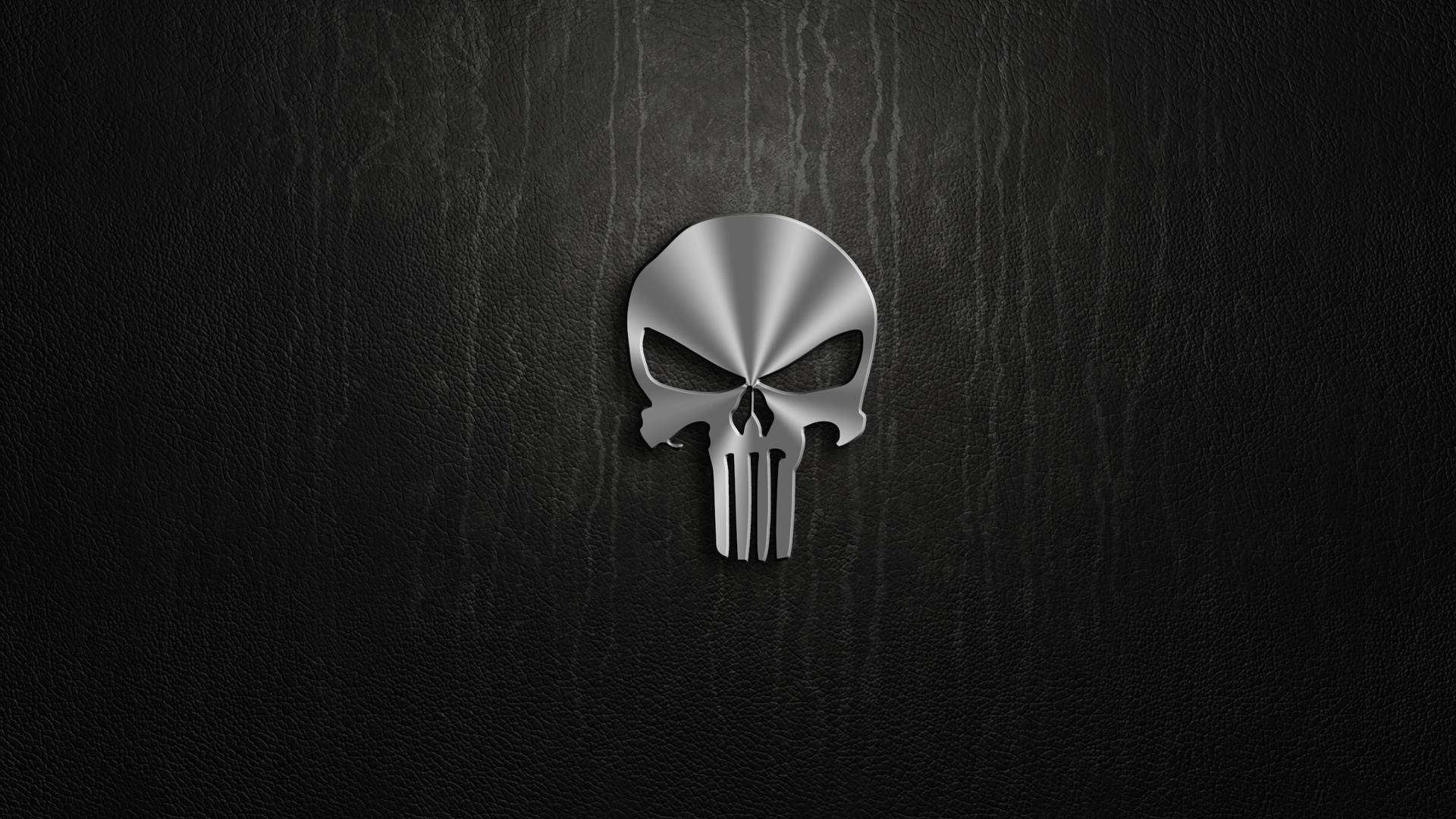 在黑色皮革表面上閃亮的金屬 Punisher 頭骨