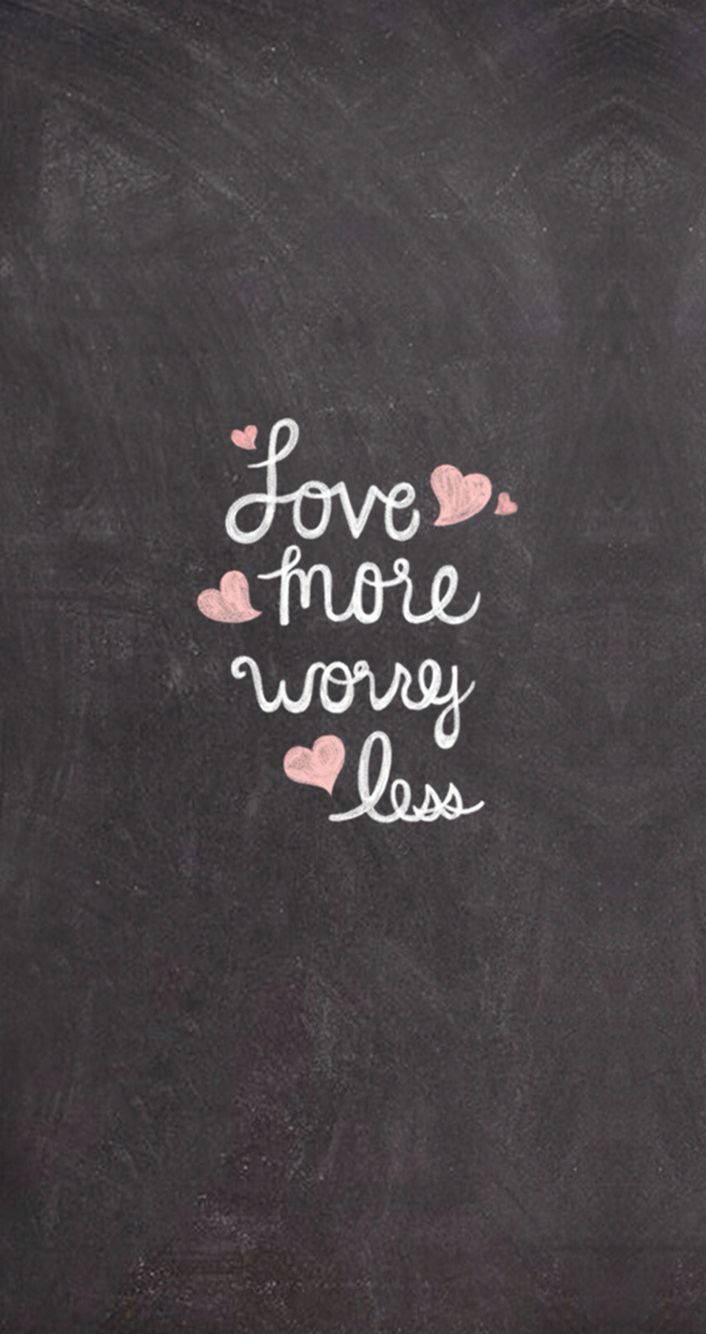 帶有草書文字「Love more worry less」和粉紅色心形的黑板。