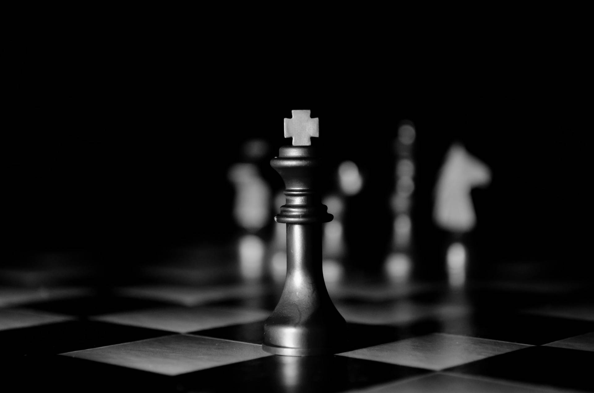 一個國王棋子聚焦在棋盤上，其他棋子模糊地在背景中。