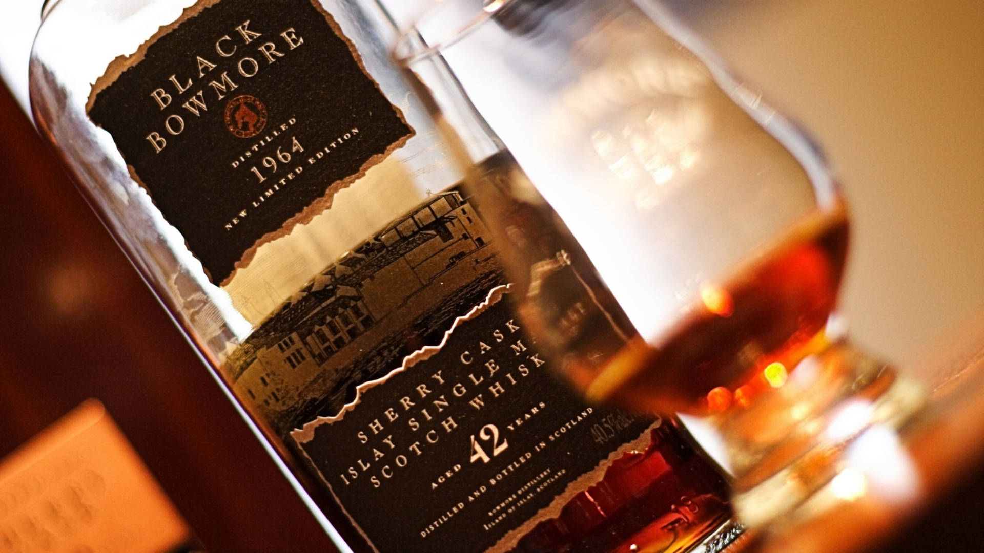 一瓶Black Bowmore 42年威士忌旁邊放著一杯琥珀色液體。