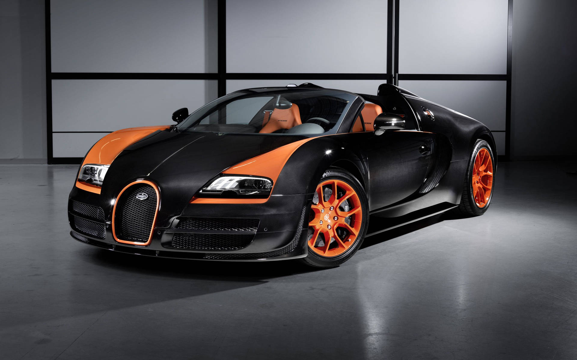 黑色和橙色Bugatti Veyron超級跑車在工作室中，帶有戲劇性的燈光。
