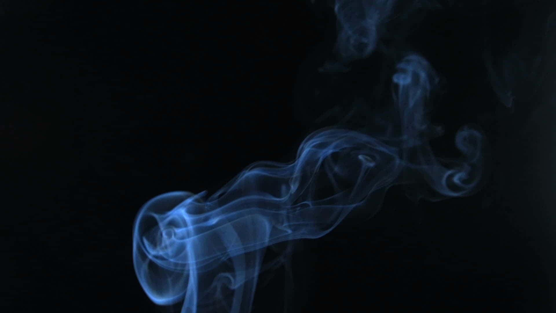黑煙雲層與藍天形成強烈對比 壁紙 — 空靈的藍色煙霧在深邃的黑色虛空中優雅地盤旋，形成迷人的抽象形態。