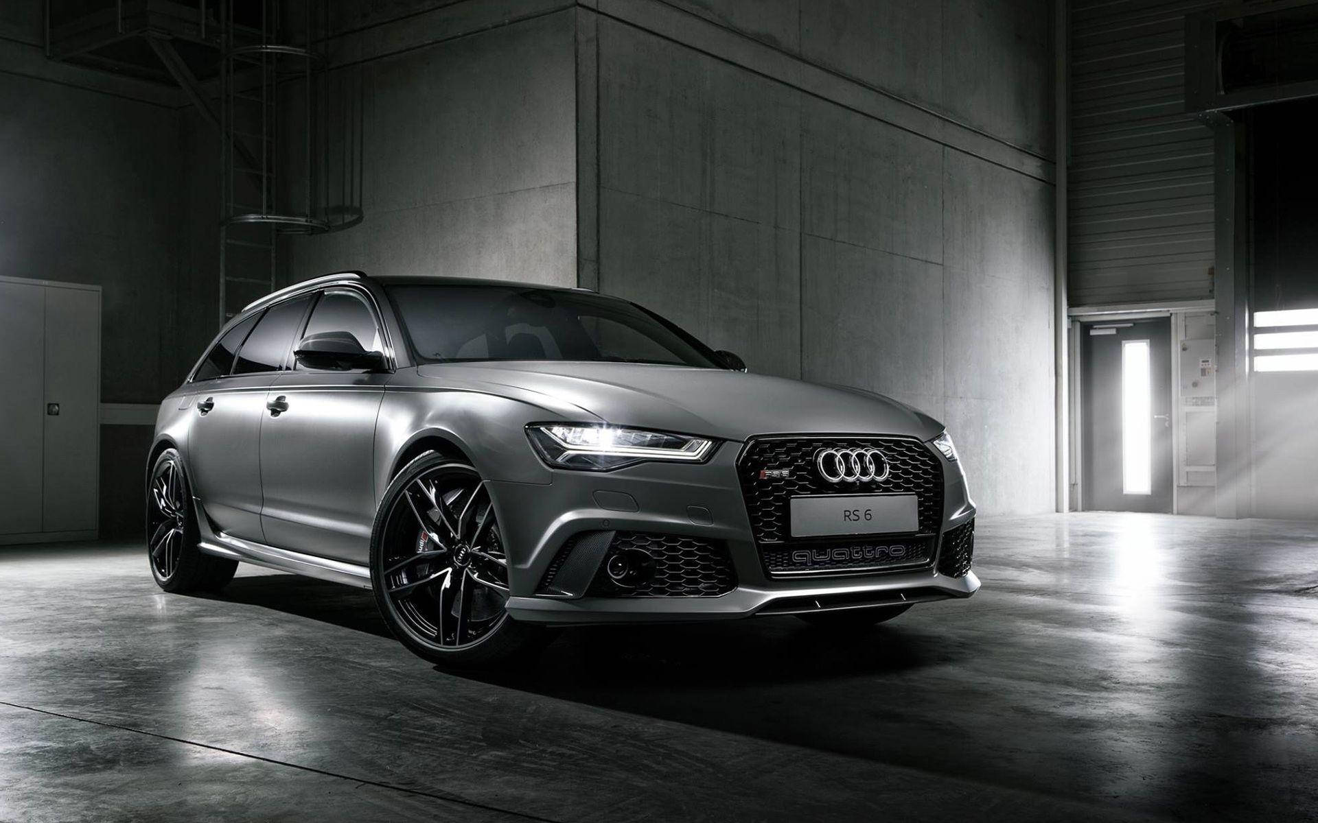 黑白 Audi RS 6 壁紙 — 一輛時尚的銀色奧迪RS6 Avant旅行車在簡約混凝土倉庫中，在戲劇性的工作室燈光下閃閃發光。