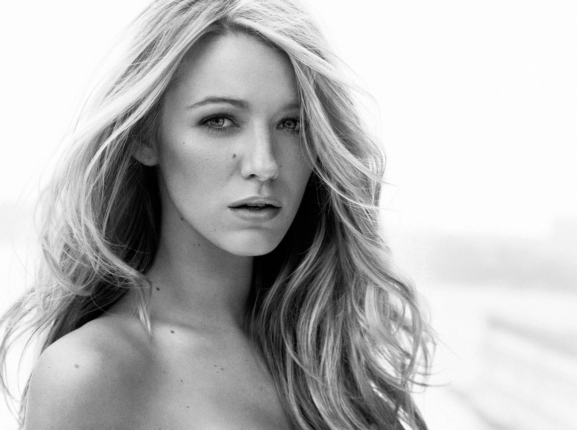 黑白 Blake Lively 壁紙 — 一位頭髮隨風飄揚的女性黑白肖像，她以柔和的表情直視鏡頭。
