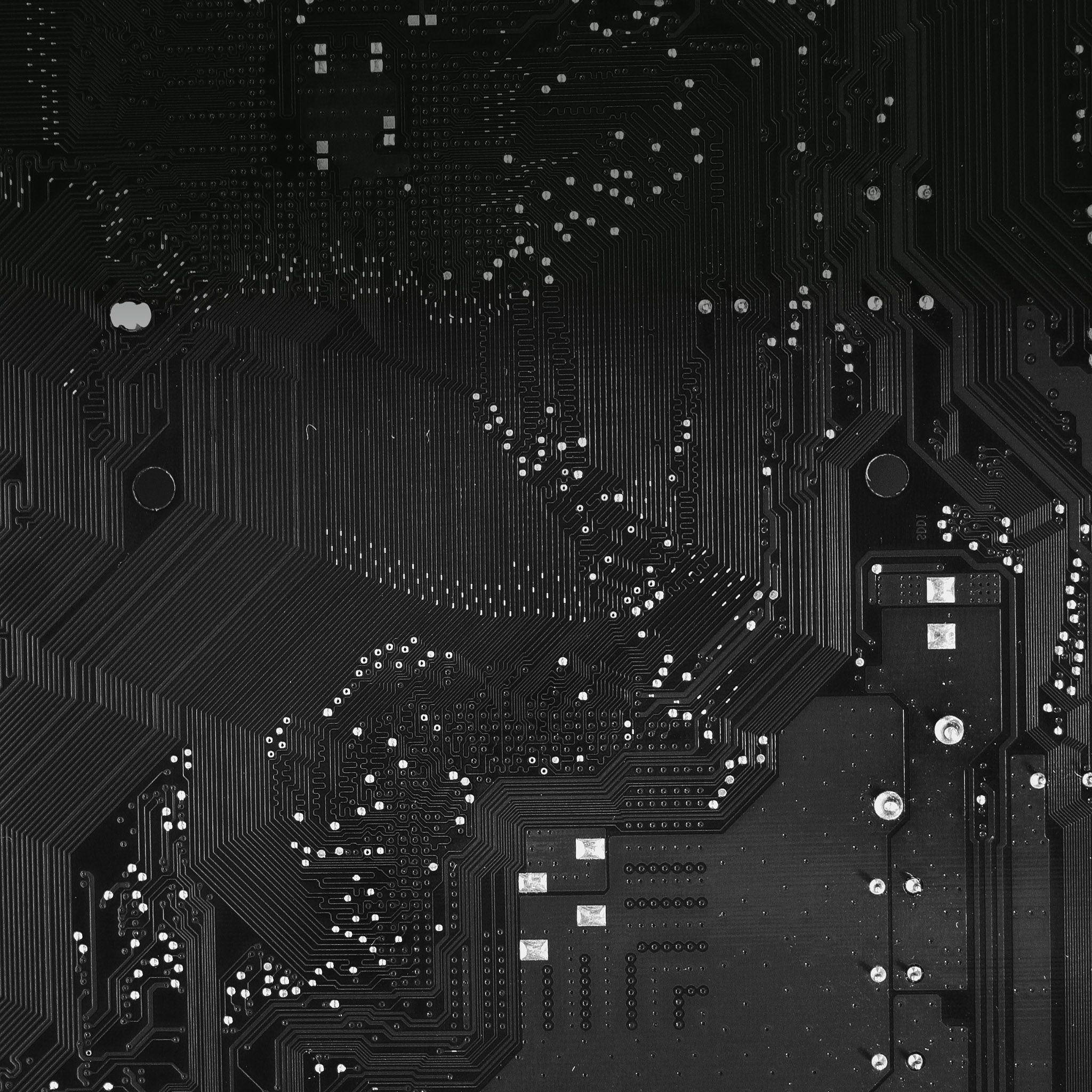 黑白主機板 壁紙 — 黑色電路板的特寫，具有複雜的銀色路徑和焊點，在均勻照明下。