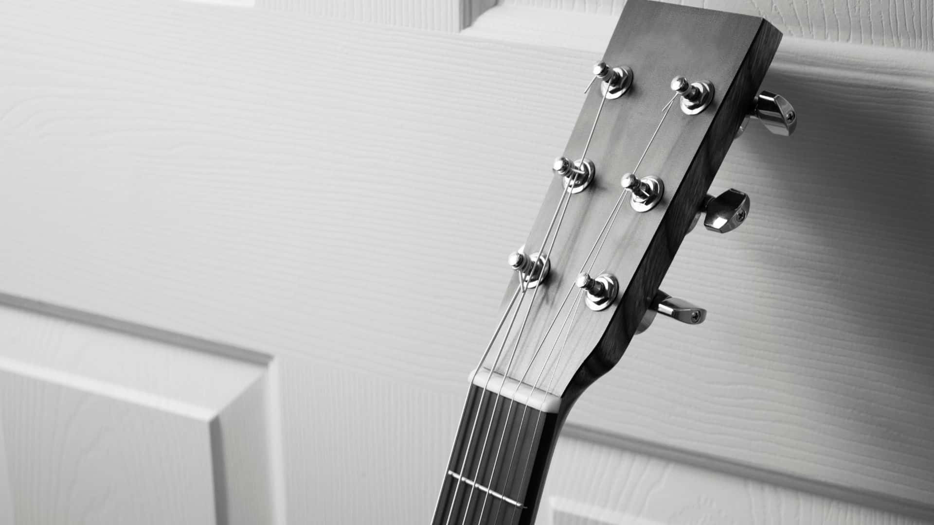 Black And White Guitar 桌布 壁紙 — 黑白單色中，白色鑲板門上的結他頭部及調音栓特寫。