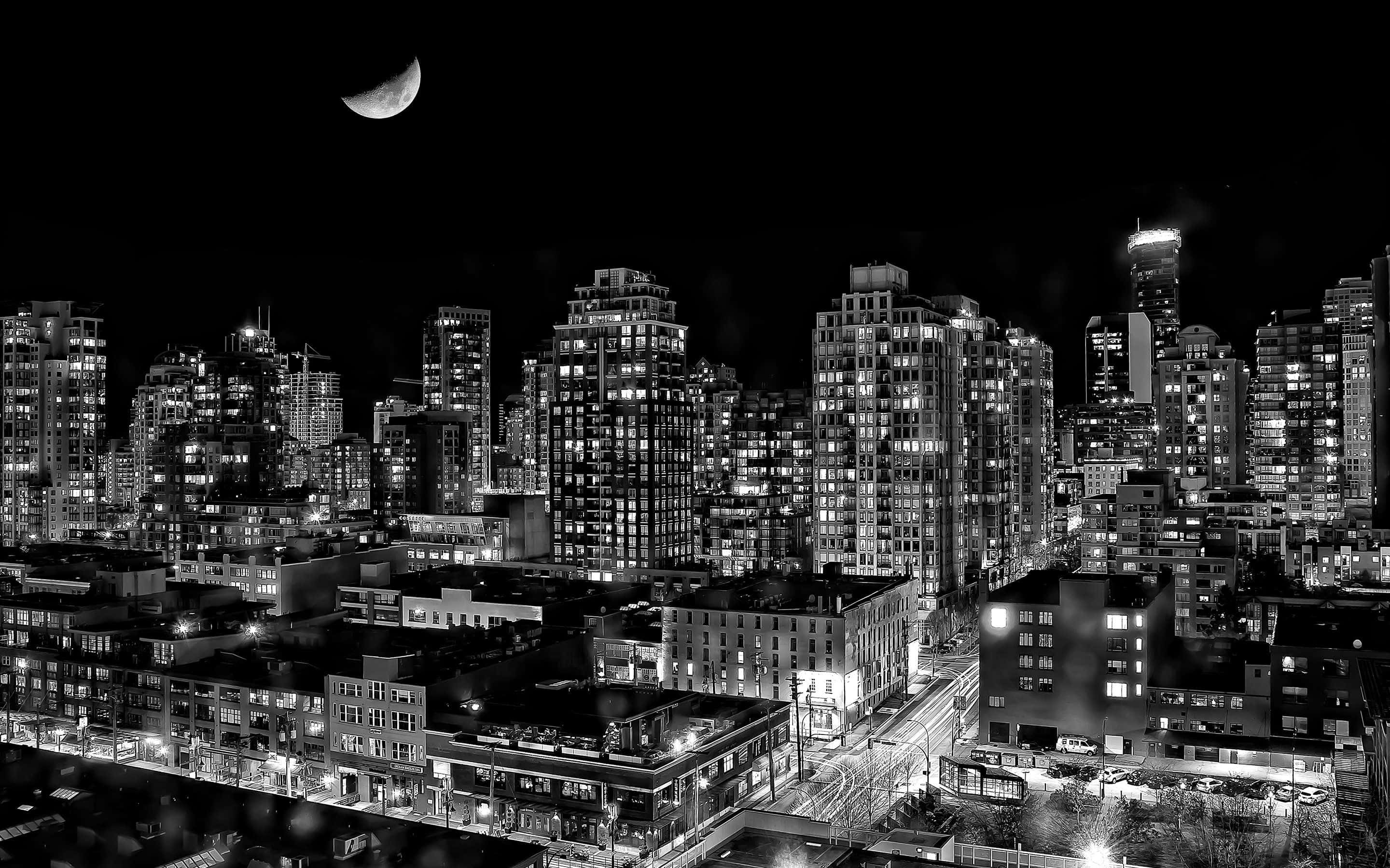 Black And White Street 桌布 壁紙 — 黑白夜景城市景觀，新月高掛在閃爍的摩天大樓和街燈之上。
