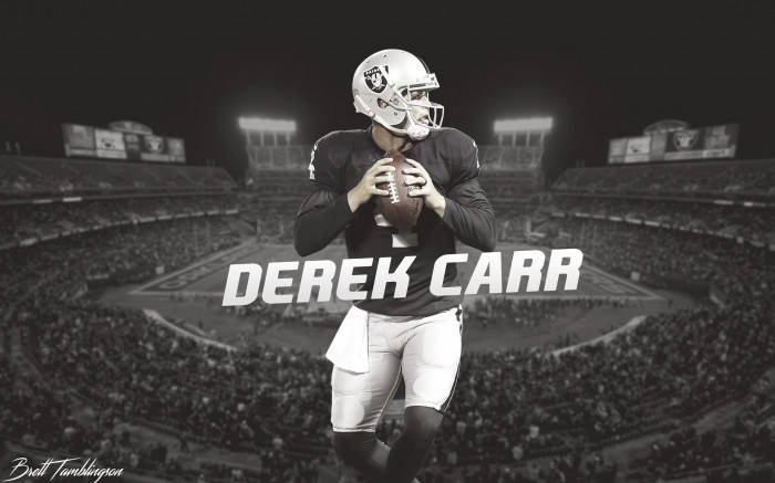 美式足球四分衛Derek Carr在夜晚的滿座體育館中行動。