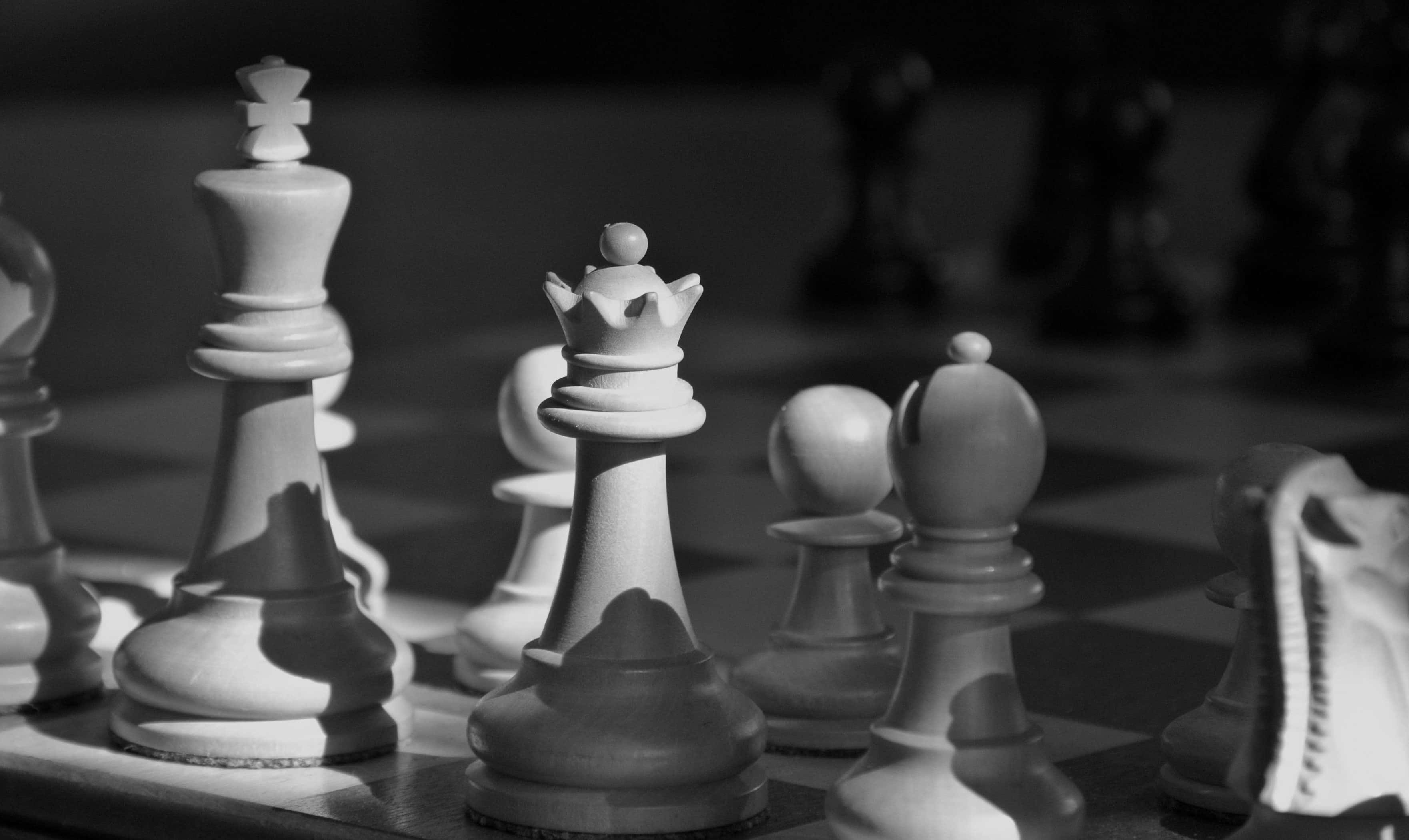 國際象棋 桌布 壁紙 — 黑白棋盤上棋子的特寫，戲劇性燈光及淺景深效果。